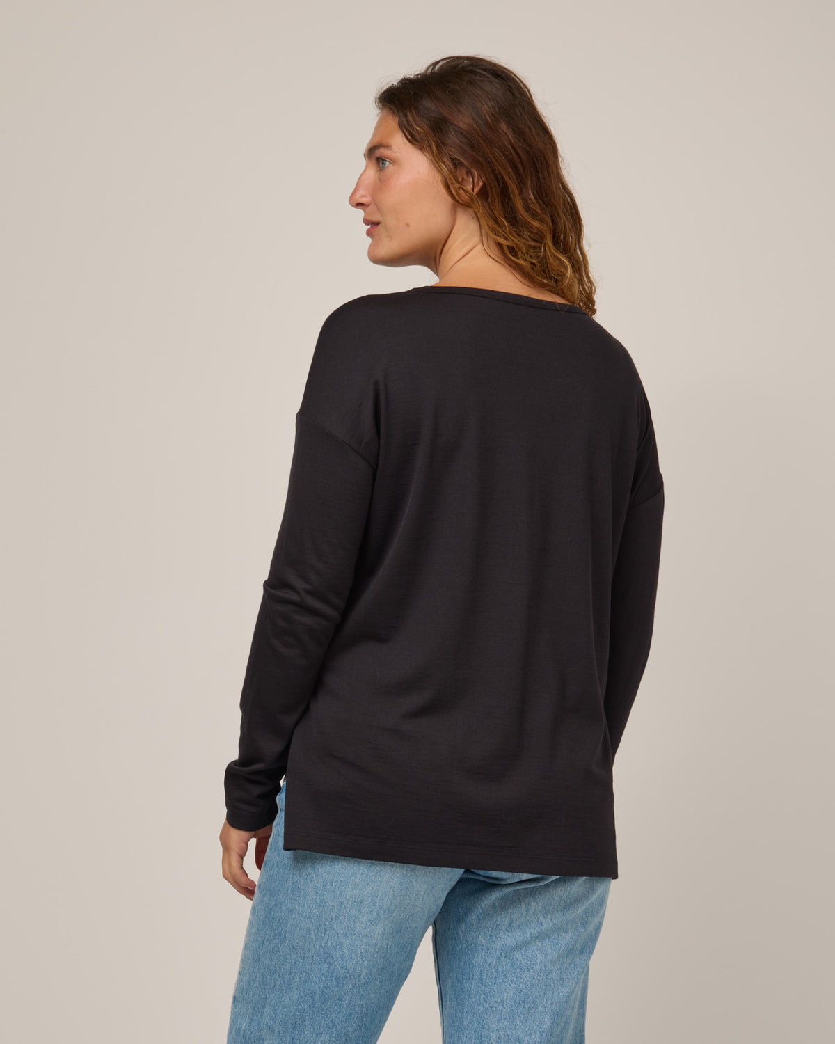 Model wearing Abby Boatneck Top in Black. Abby Boatneck Top is a merino wool long sleeve, boatneck, relaxed fit top available in sizes XS-3X.