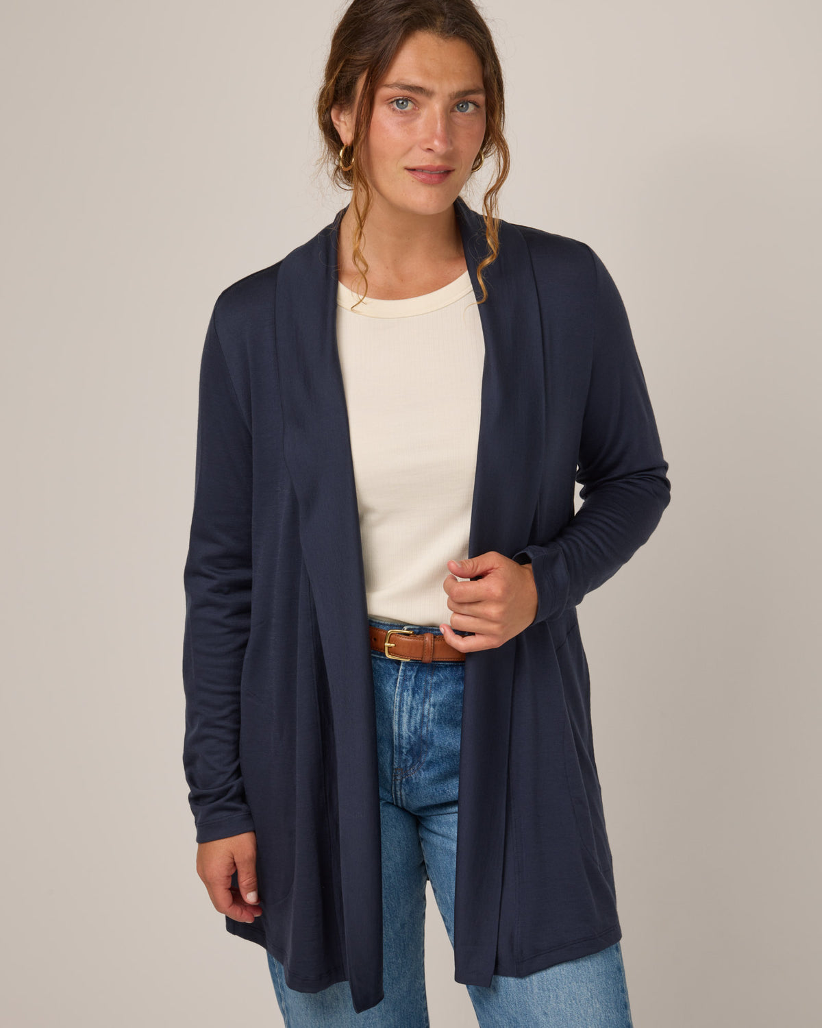 Model wearing Landmark Cardigan in Washed Navy. Landmark Cardigan is a merino wool long sleevecardigan with pockets available in sizes XS-3X.