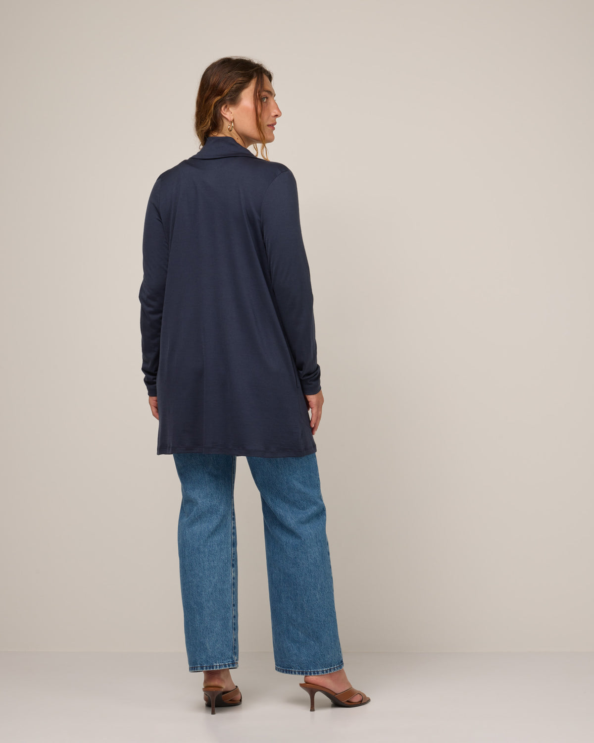 Model wearing Landmark Cardigan in Washed Navy. Landmark Cardigan is a merino wool long sleevecardigan with pockets available in sizes XS-3X.