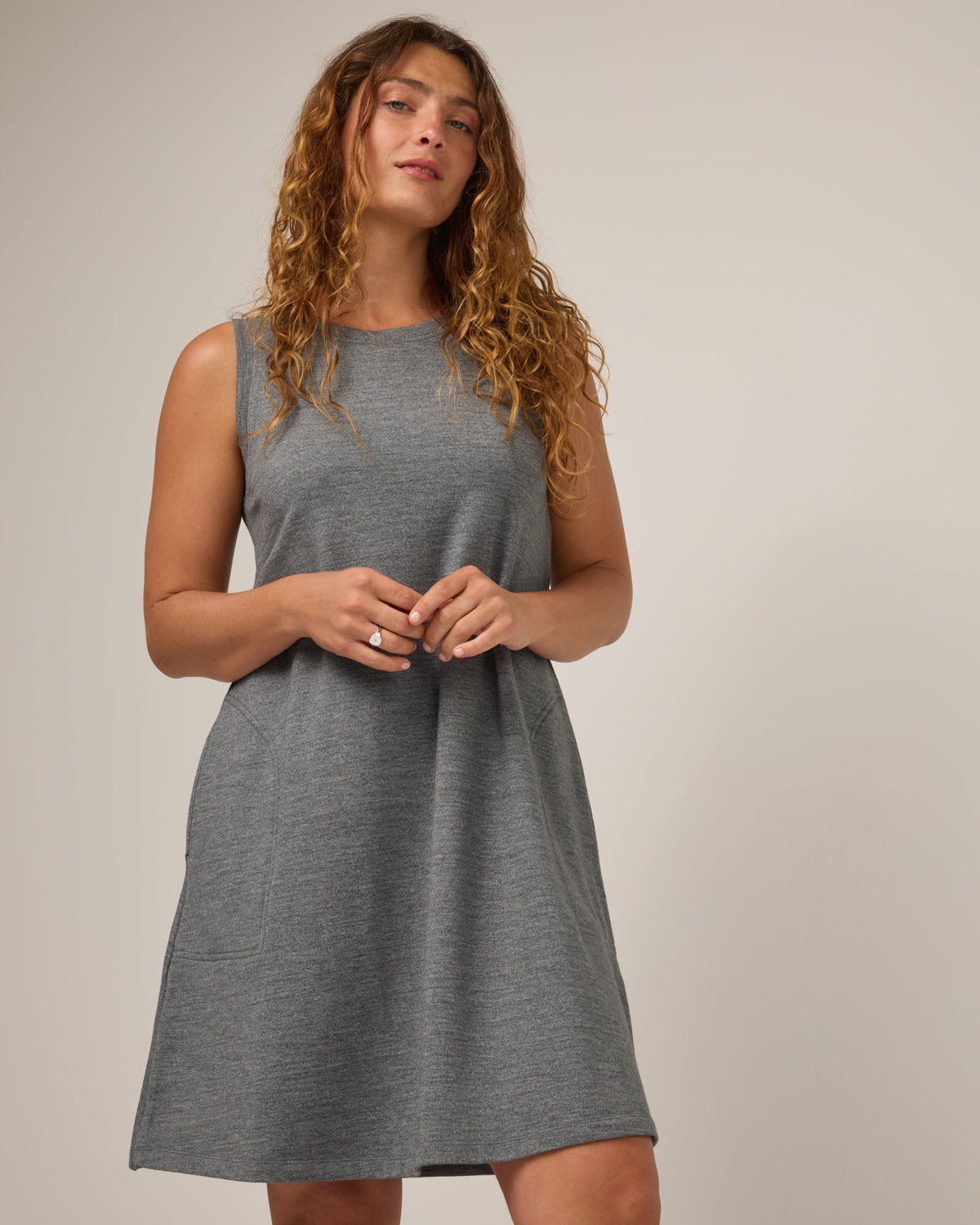 Model wearing Sierra Tank Dress in Charcoal Heather. Sierra Tank Dress is a merino wool sleeveless, crew neck, knee length swing dress with pockets available in sizes XS-3X Regular, XS-3X Long.