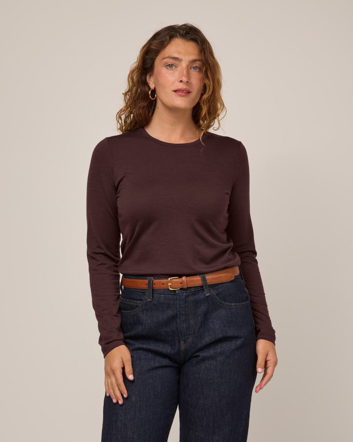 Model wearing Sloan 100% Fitted Tee in Espresso, a warm dark brown color. Sloan 100% Fitted Tee is a merino wool long sleeve, crew neck, slim fit tee available in sizes XS-3X.