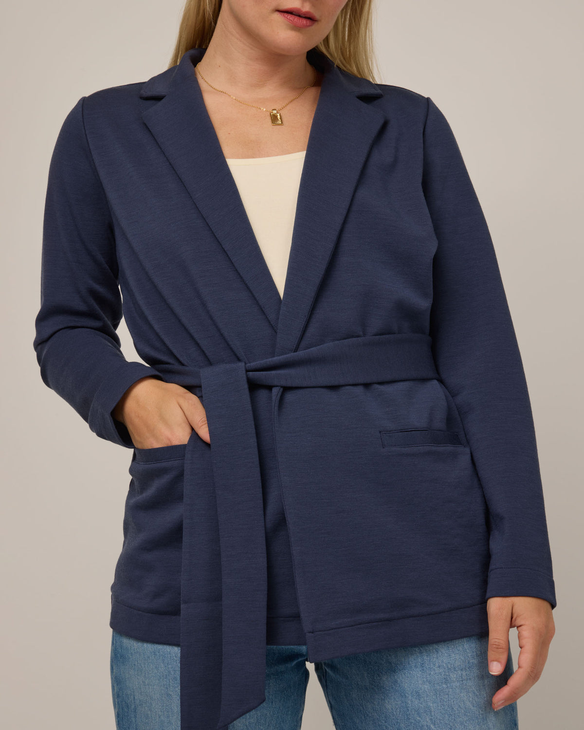 Model wearing Kristen Blazer in Washed Navy. Kristen Blazer is a merino wool long sleeve, collared, regular fit jacket with pockets available in sizes XS-XXL.