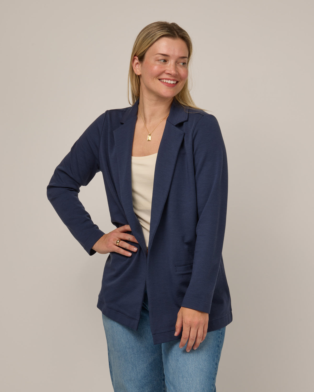 Model wearing Kristen Blazer in Washed Navy. Kristen Blazer is a merino wool long sleeve, collared, regular fit jacket with pockets available in sizes XS-XXL.