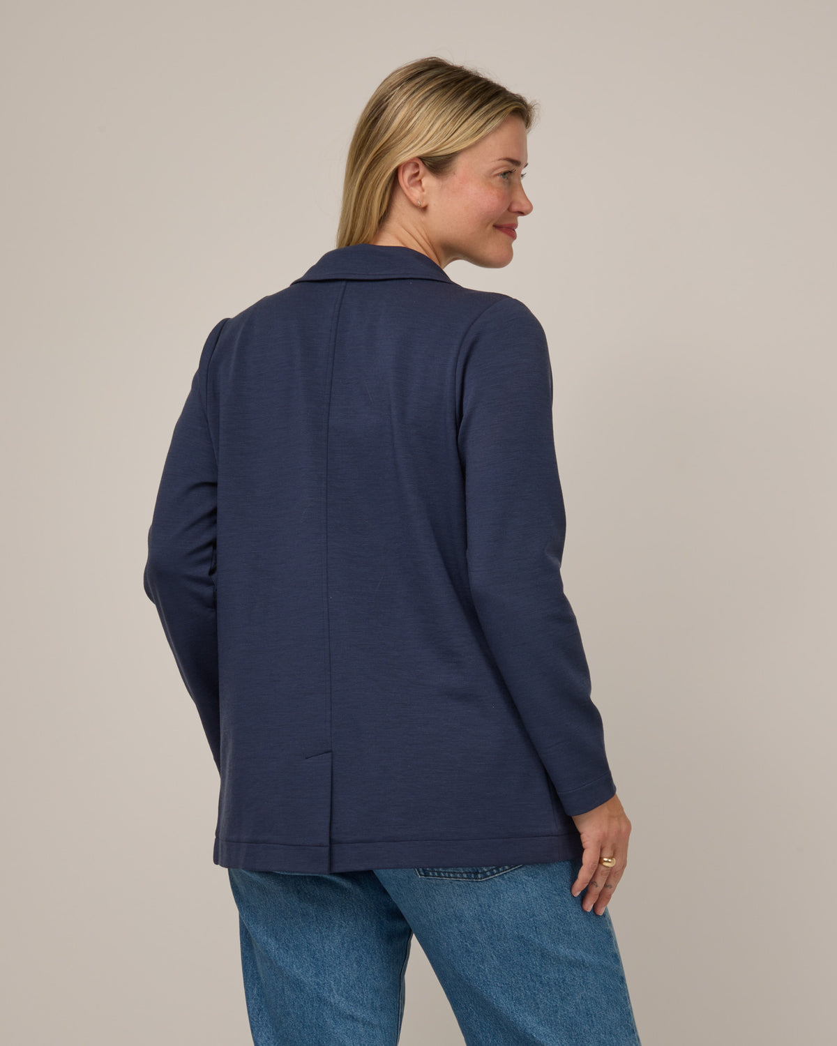 Model wearing Kristen Blazer in Washed Navy. Kristen Blazer is a merino wool long sleeve, collared, regular fit jacket with pockets available in sizes XS-XXL.