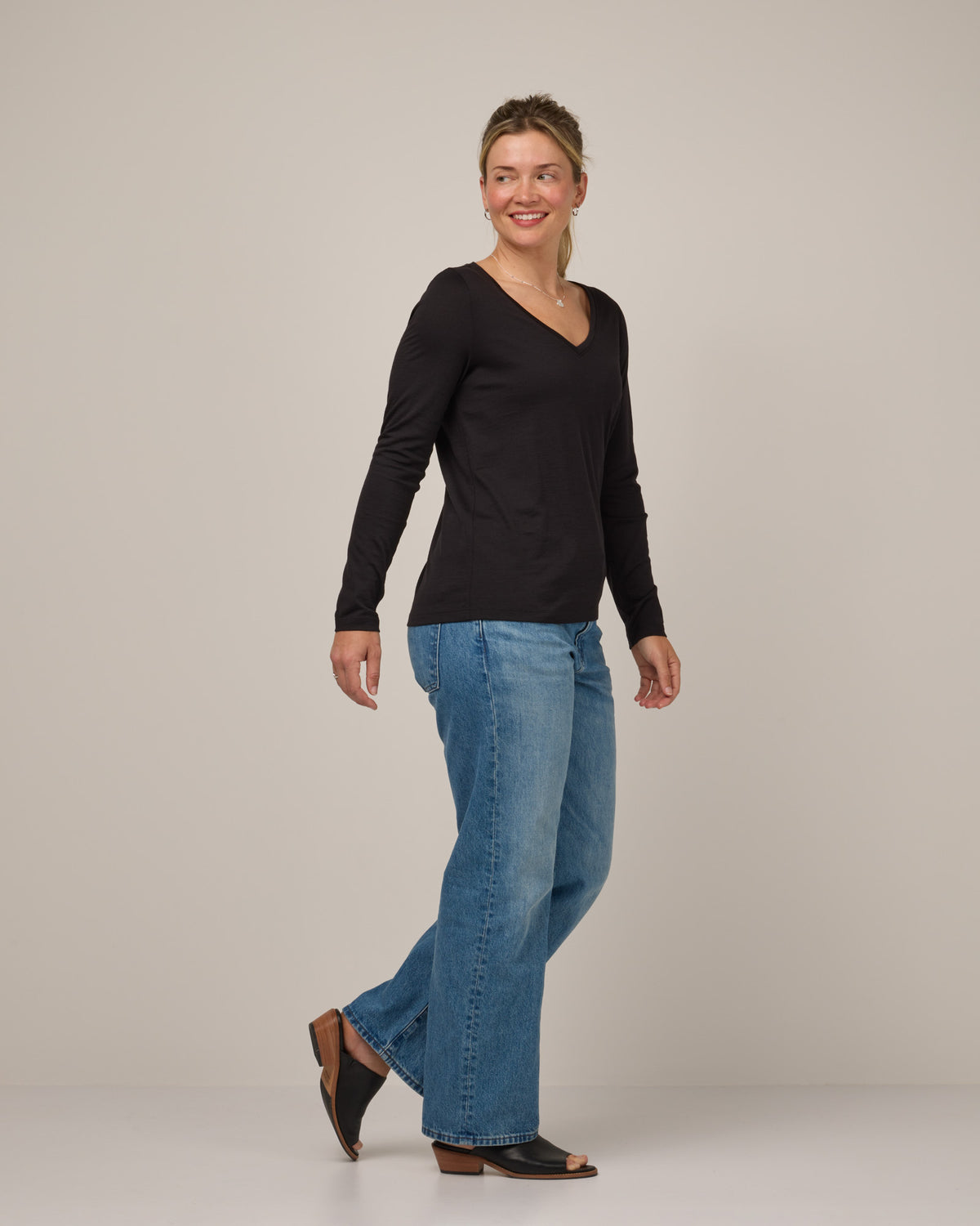 Model wearing Brenton V-Neck Tee in Black. Brenton V-Neck Tee is a merino wool long sleeve, v-neck, regular fit tee available in sizes XS-3X.
