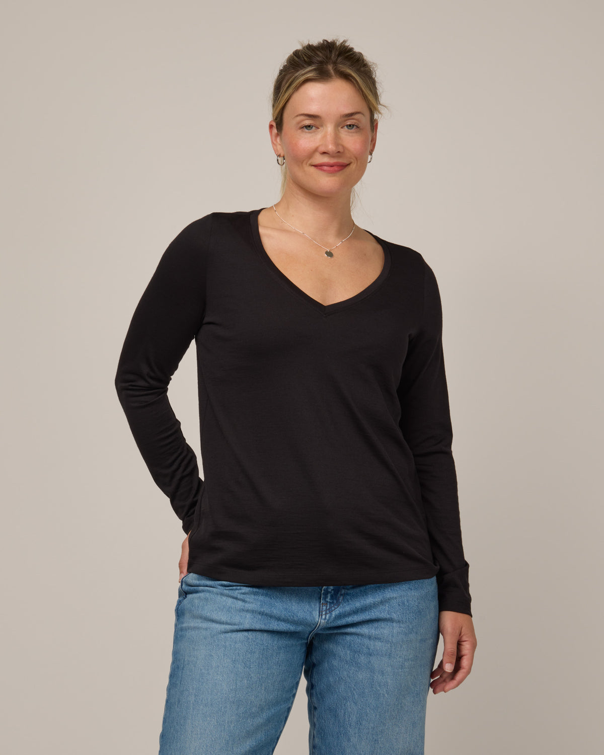 Model wearing Brenton V-Neck Tee in Black. Brenton V-Neck Tee is a merino wool long sleeve, v-neck, regular fit tee available in sizes XS-3X.