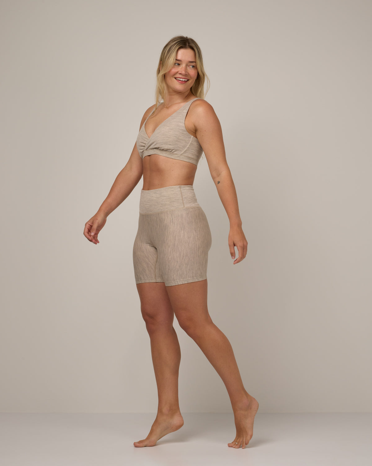 Model wearing Roam Bike Short in Oatmeal Heather, a soft heathered cream color. Roam Bike Short is a merino wool short with pockets available in sizes XS-3X.