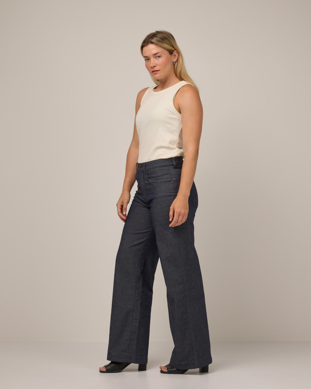 Model wearing Beck Wide Leg Denim Jean in Indigo Blue. Beck Wide Leg Denim Jean is a merino wool pant with pockets available in sizes 26-36.