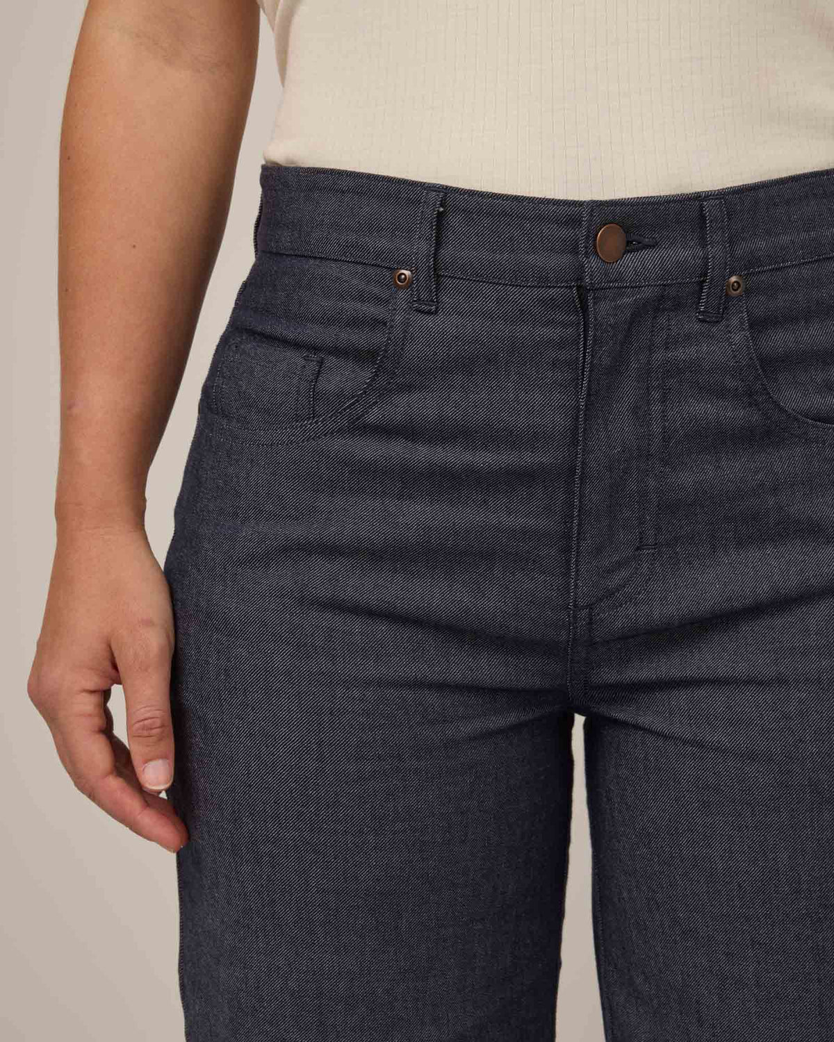 Model wearing Beck Wide Leg Denim Jean in Indigo Blue. Beck Wide Leg Denim Jean is a merino wool pant with pockets available in sizes 26-38.