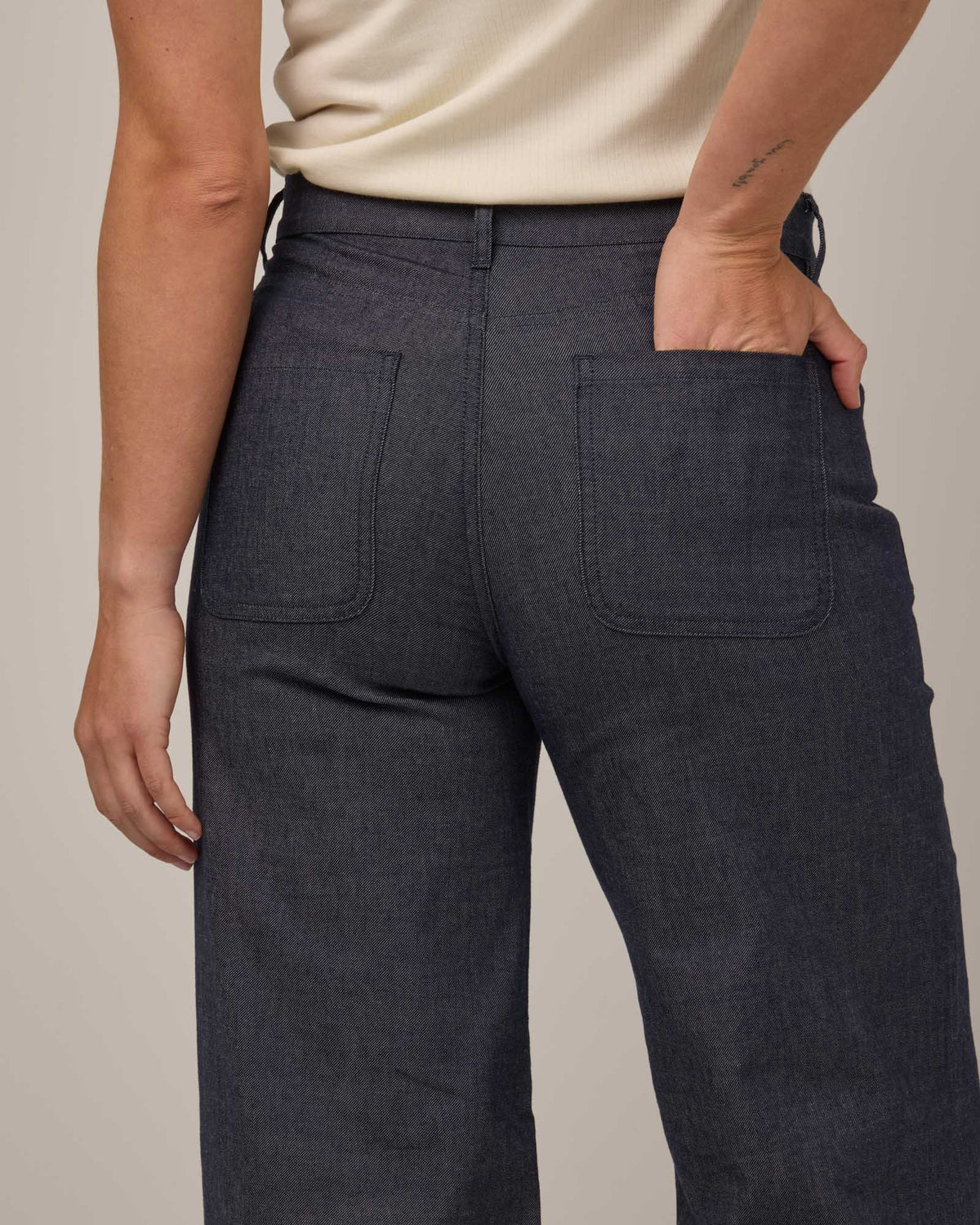 Model wearing Beck Wide Leg Denim Jean in Indigo Blue. Beck Wide Leg Denim Jean is a merino wool pant with pockets available in sizes 26-39.