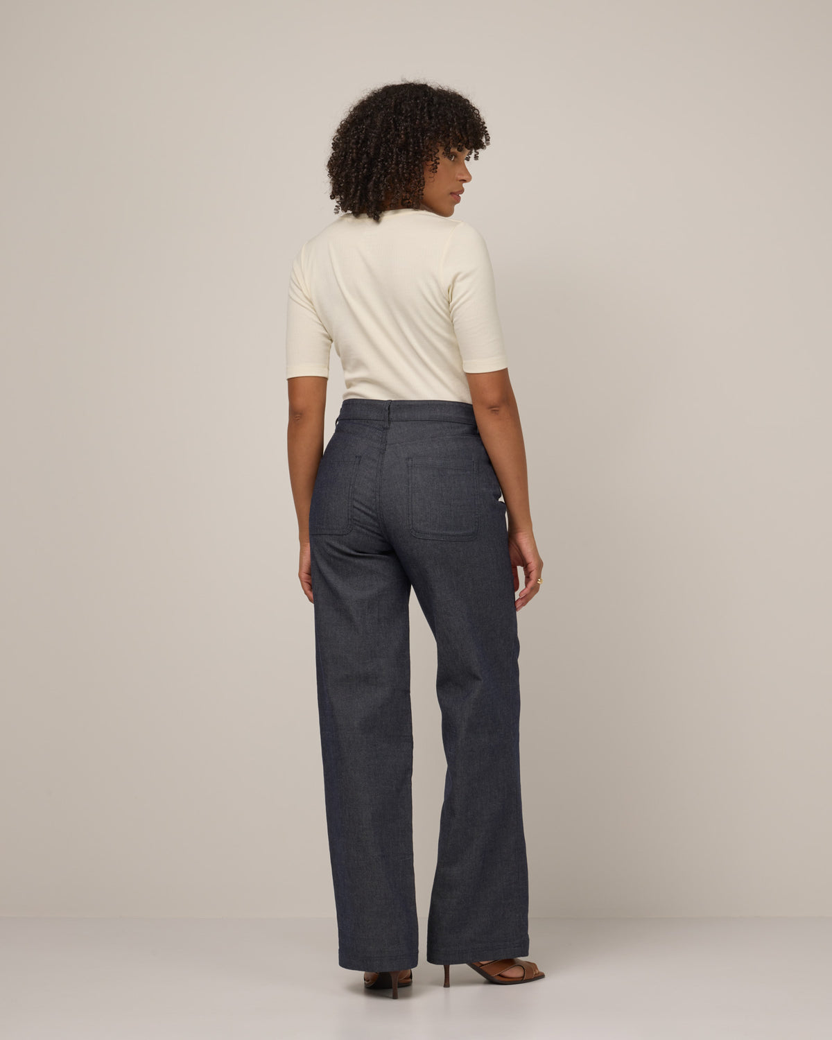Model wearing Beck Wide Leg Denim Jean in Indigo Blue. Beck Wide Leg Denim Jean is a merino wool pant with pockets available in sizes 26-41.