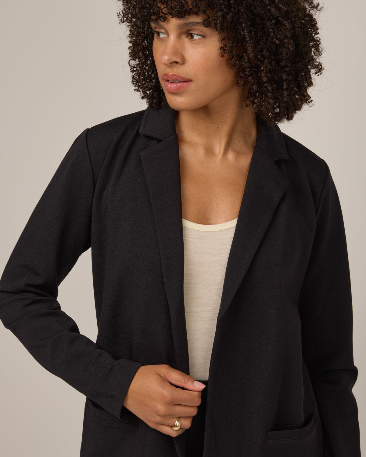 Model wearing Kristen Blazer in Black. Kristen Blazer is a merino wool long sleeve, collared, regular fit jacket with pockets available in sizes XS-XXL.