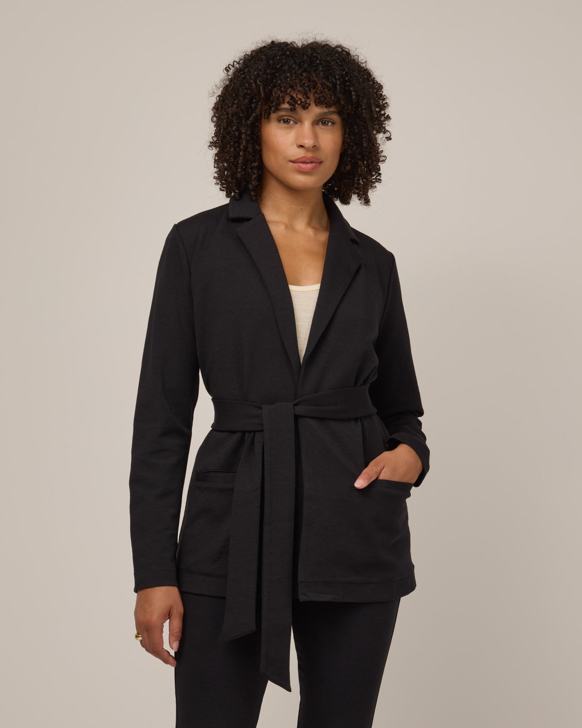 Model wearing Kristen Blazer in Black. Kristen Blazer is a merino wool long sleeve, collared, regular fit jacket with pockets available in sizes XS-XXL.