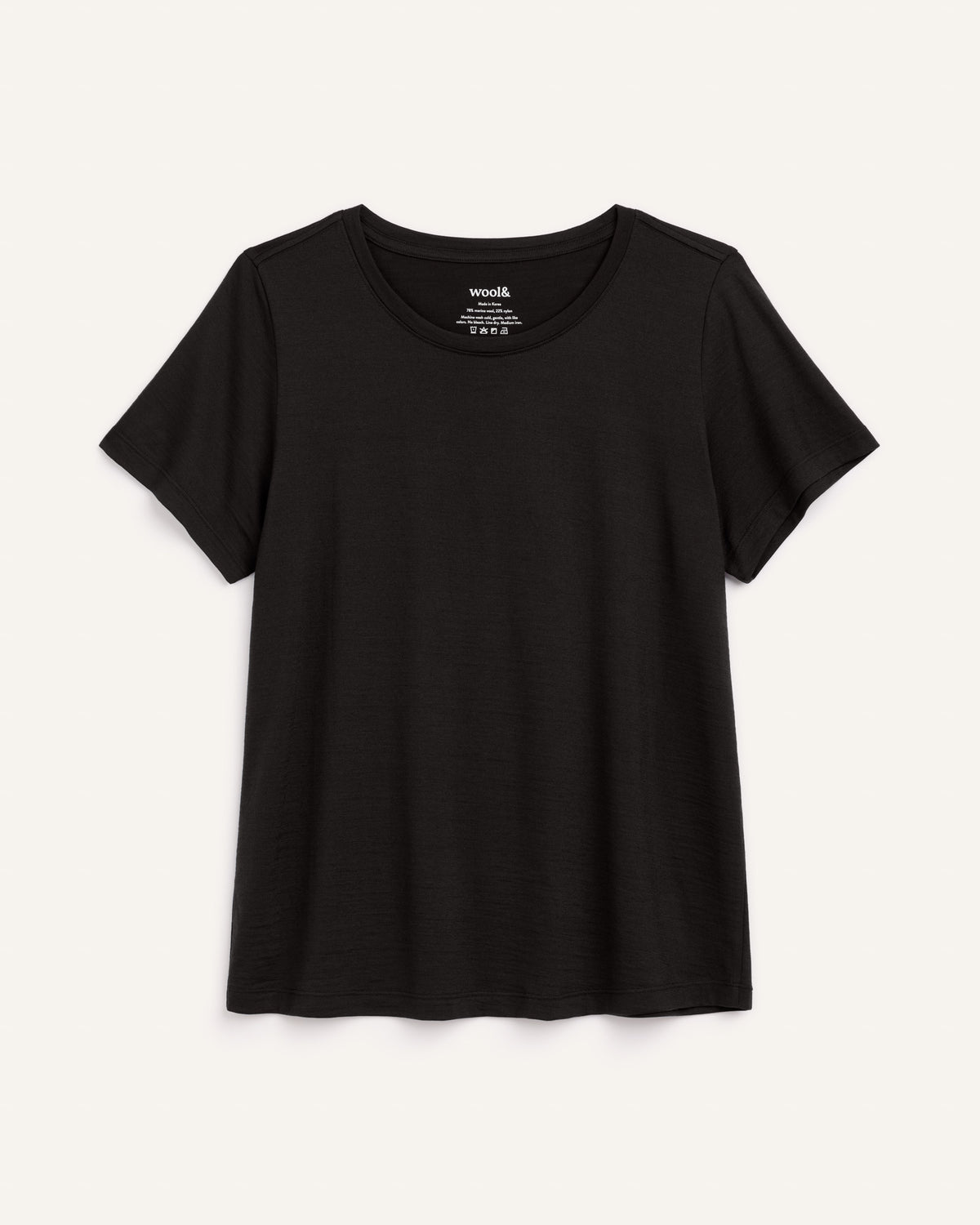 Laydown of Zoe Easy Crew Neck Tee in Black. Zoe Easy Crew Neck Tee is a merino wool short sleeve, crew neck, regular fit tee available in sizes XS-3X.