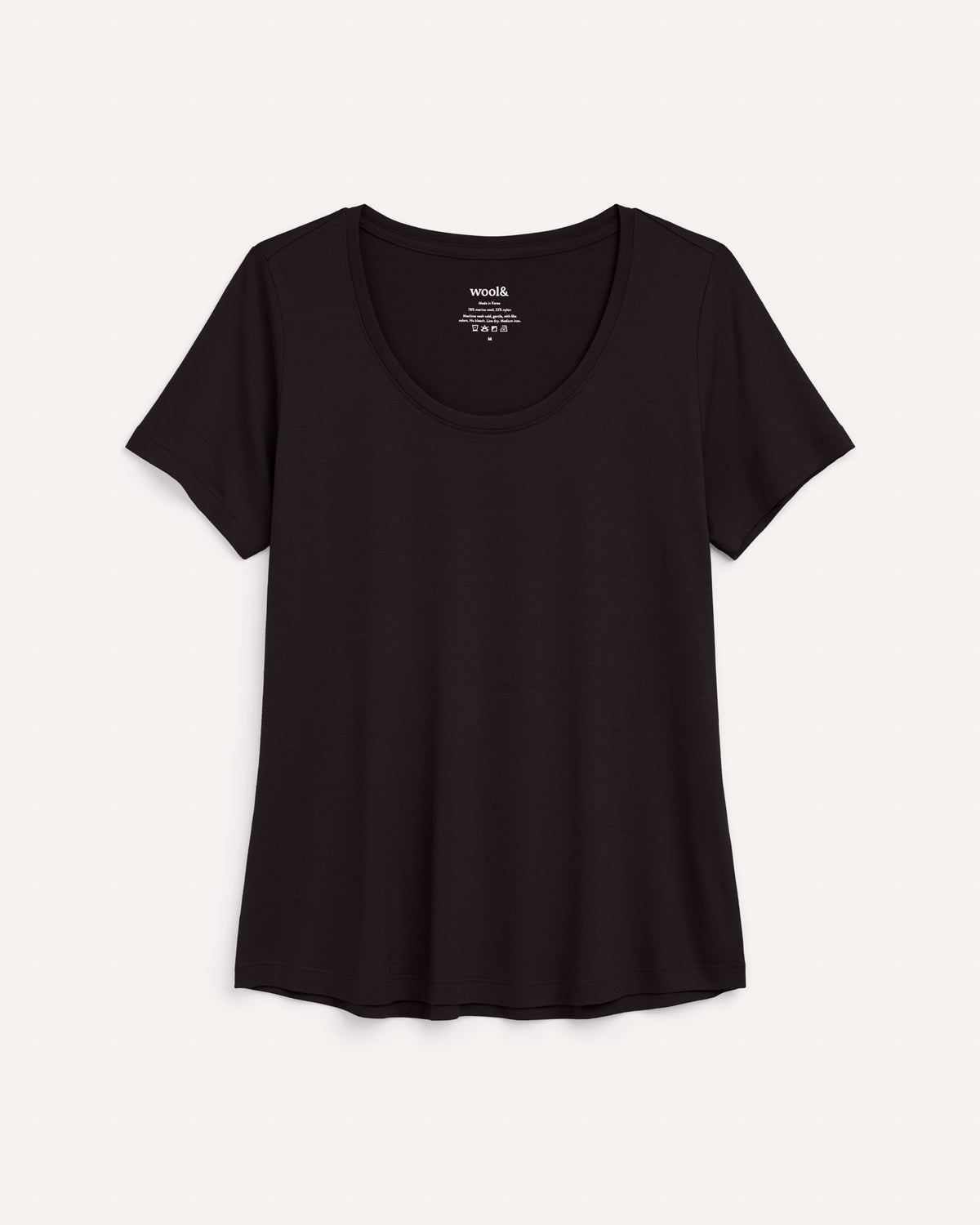 Laydown of Stella Signature Scoop Neck Tee in Black. Stella Signature Scoop Neck Tee is a merino wool short sleeve, scoop neck, relaxed fit tee available in sizes XS-3X.