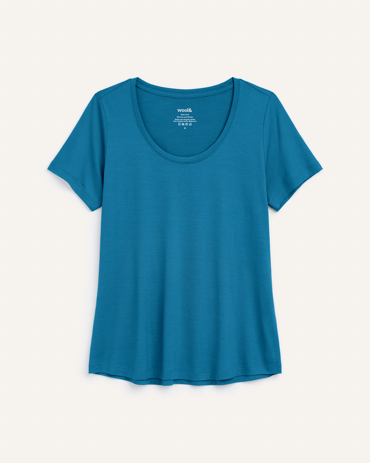 Laydown of Stella Signature Scoop Neck Tee in Ocean Teal, a medium blue-green color. Stella Signature Scoop Neck Tee is a merino wool short sleeve, scoop neck, relaxed fit tee available in sizes XS-3X.