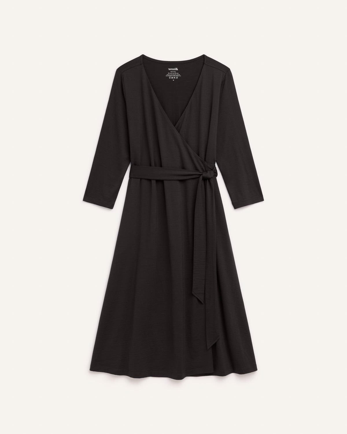 Laydown of Alana Wrap Dress in Black. Alana Wrap Dress is a merino wool long sleeve, v-neck, midi fit & flare dress with pockets available in sizes XS-3X.