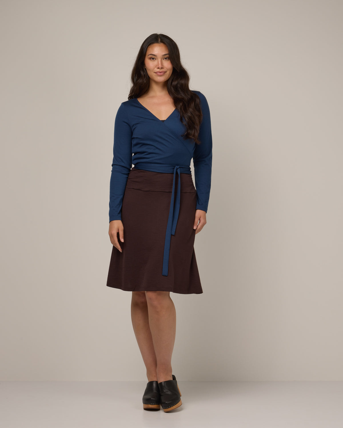 Model wearing Helena Skirt in Espresso, a dark brown color. Helena Skirt is a merino wool knee length skirt with pockets available in sizes XS-3X.