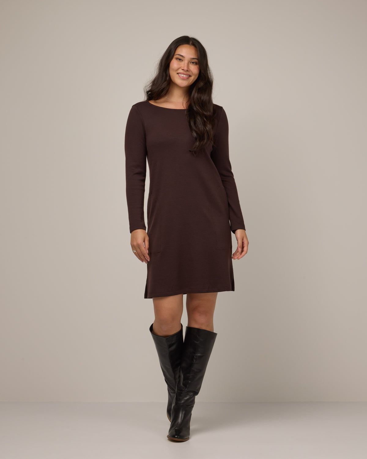 Model wearing Margo Shift Dress in Espresso, a dark brown color. Margo Shift Dress is a merino wool long sleeve, boatneck, knee length shift dress with pockets available in sizes XS-3X Regular, S-3X Long.