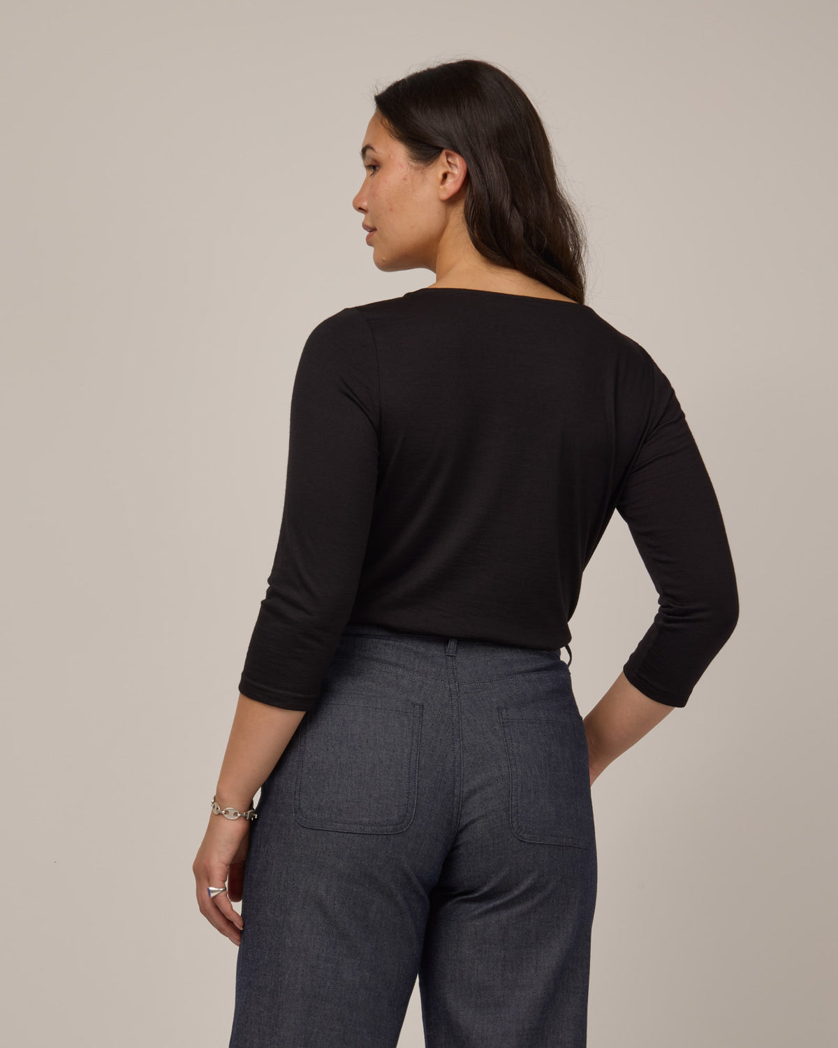 Model wearing Colette Quarter-Sleeve Top in Black. Colette Quarter-Sleeve Top is a merino wool long sleeve, boatneck, regular fit top available in sizes XS-3X.