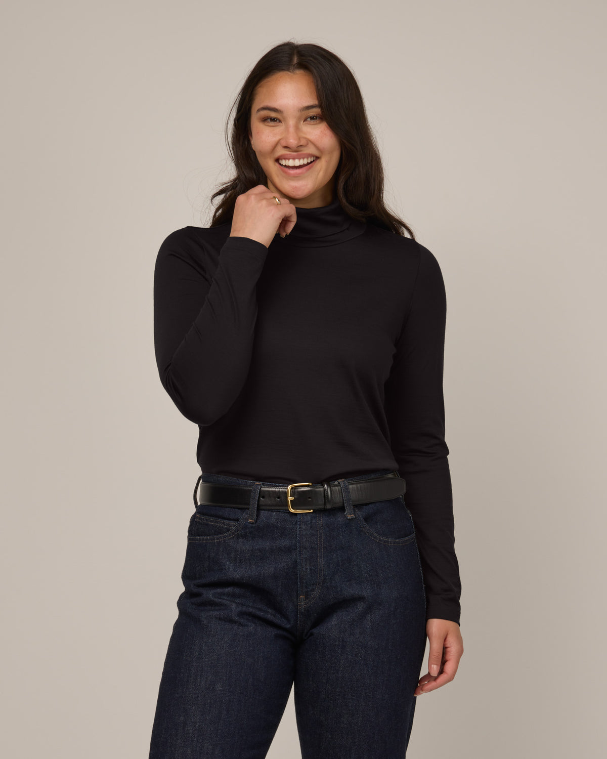 Model wearing Addison Turtleneck Top in Black. Addison Turtleneck Top is a merino wool long sleeve, turtleneck, slim fit top available in sizes XS-3X.