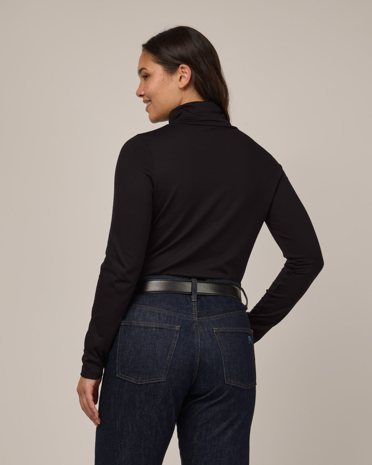 Model wearing Addison Turtleneck Top in Black. Addison Turtleneck Top is a merino wool long sleeve, turtleneck, slim fit top available in sizes XS-3X.