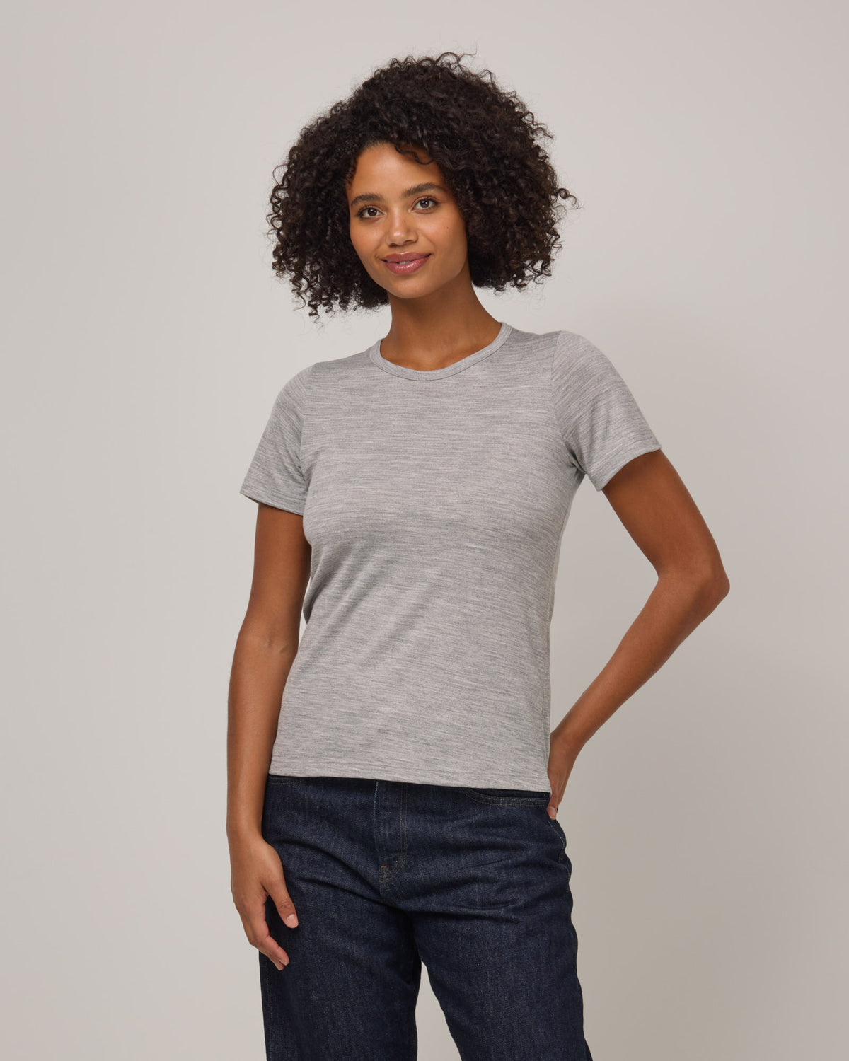 Model wearing Cara Signature Fitted Tee in Gray Heather. Cara Signature Fitted Tee is a merino wool short sleeve, crew neck, slim fit tee available in sizes XS-3X.