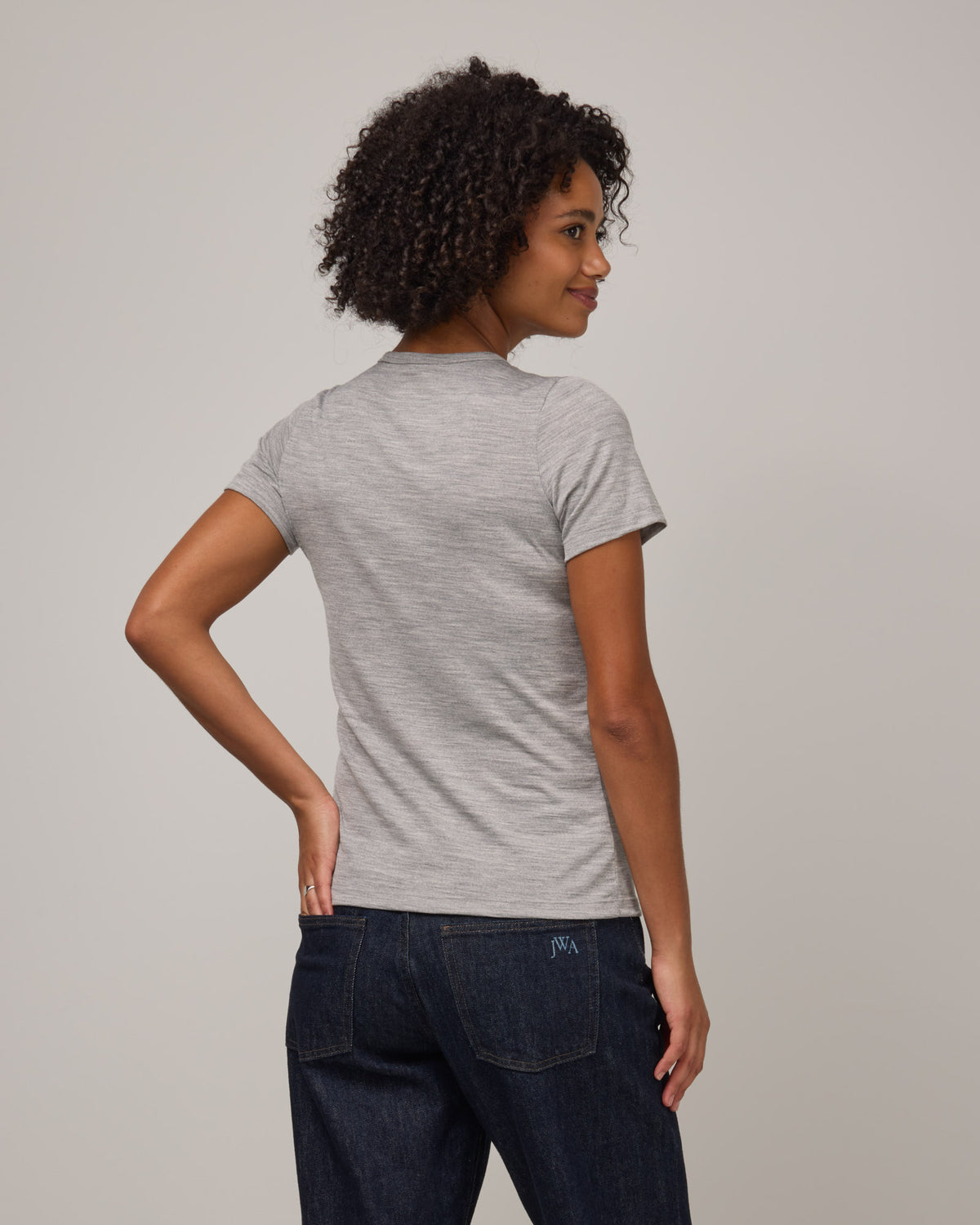Model wearing Cara Signature Fitted Tee in Gray Heather. Cara Signature Fitted Tee is a merino wool short sleeve, crew neck, slim fit tee available in sizes XS-3X.