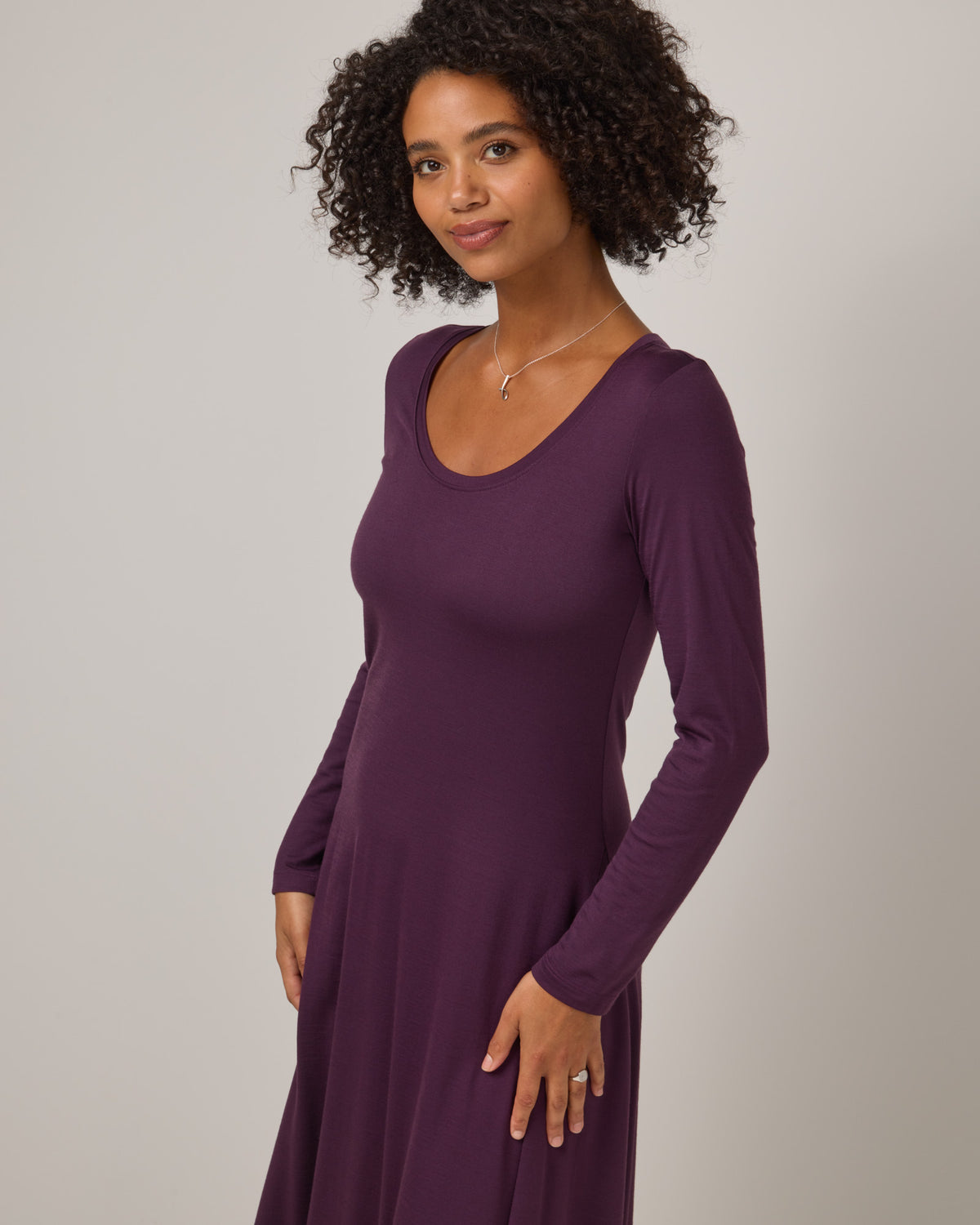 Model wearing Valerie Maxi Dress in Marionberry, a dark berry purple color. Valerie Maxi Dress is a merino wool long sleeve, scoop neck, maxi swing dress available in sizes XS-XXL.