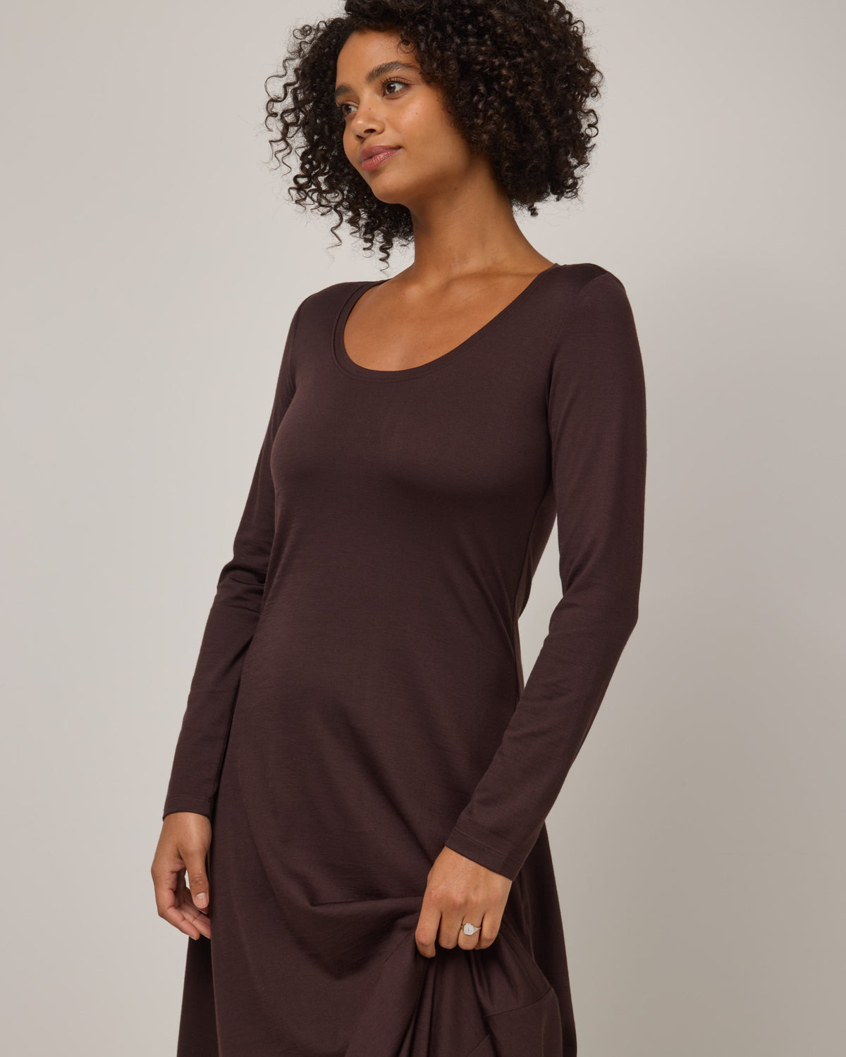 Model wearing Valerie Maxi Dress in Espresso, a dark brown color. Valerie Maxi Dress is a merino wool long sleeve, scoop neck, maxi swing dress available in sizes XS-XXL.