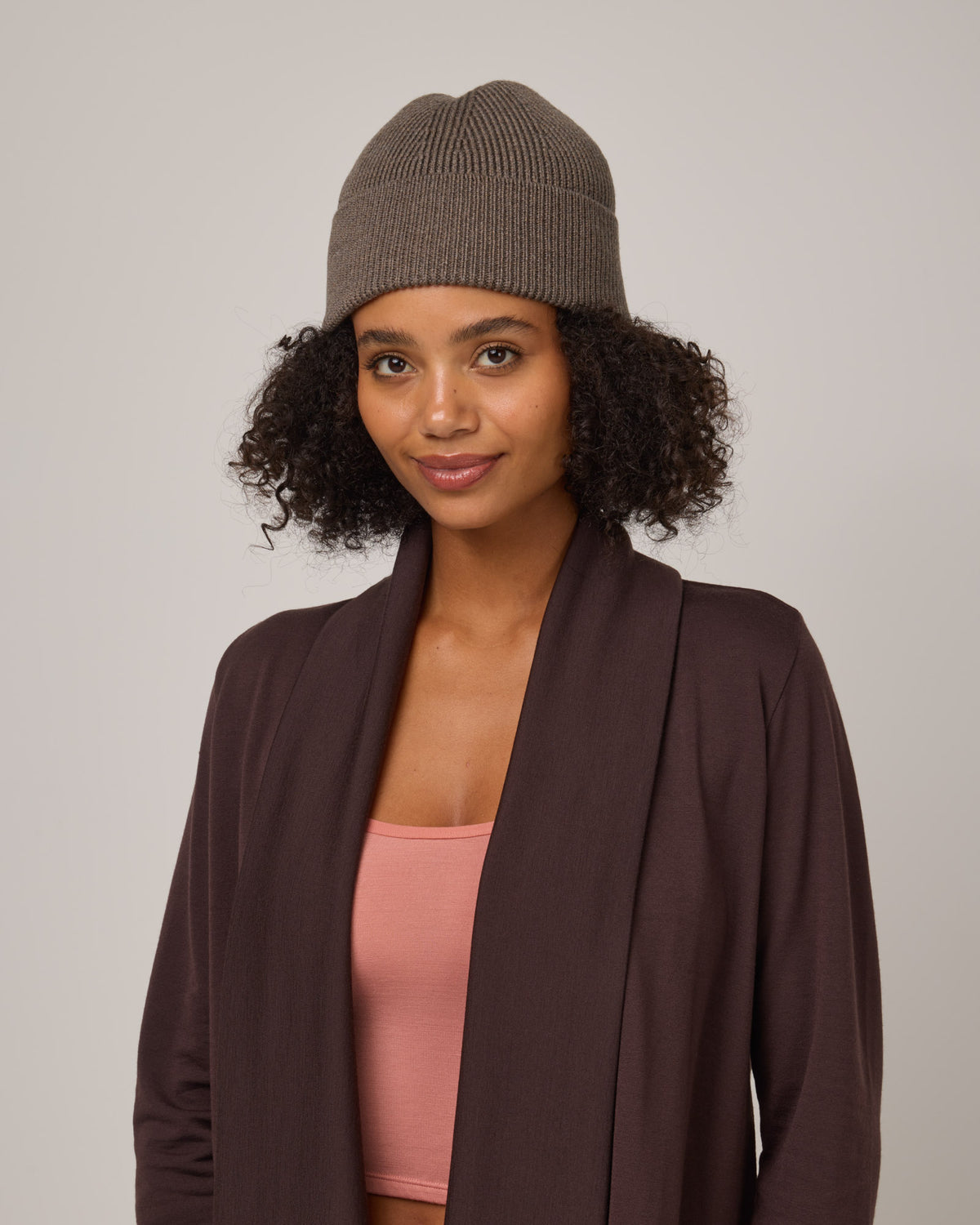 Model wearing Rory Ribbed Beanie in Brown Heather. Rory Ribbed Beanie is a merino wool hat available in one size.