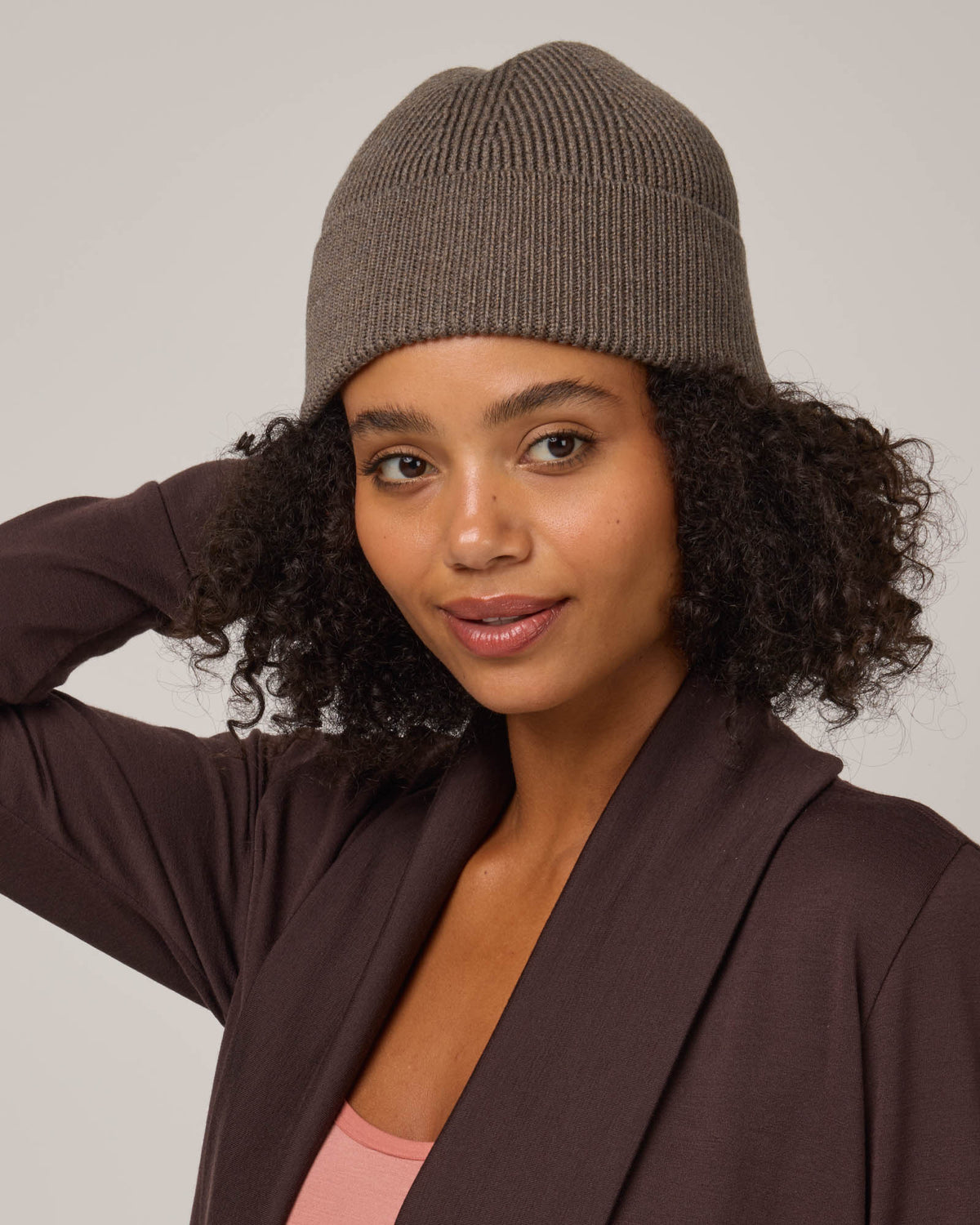 Model wearing Rory Ribbed Beanie in . Rory Ribbed Beanie is a merino wool hat available in one size.