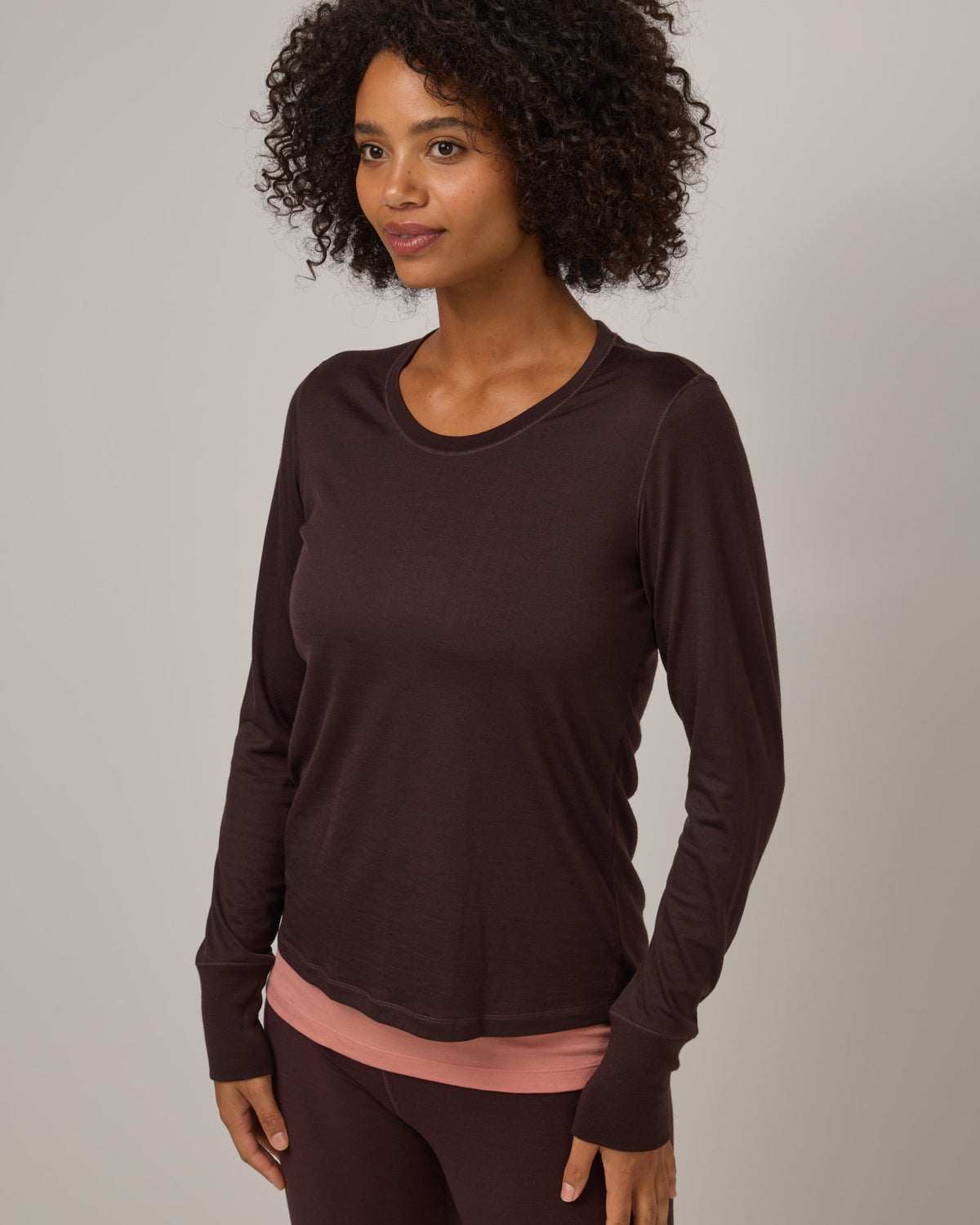 Model wearing Billie Tonal Stitch Tee in Espresso, a dark brown color. Billie Tonal Stitch Tee is a merino wool long sleeve, scoop neck, regular fit tee available in sizes XS-3X.