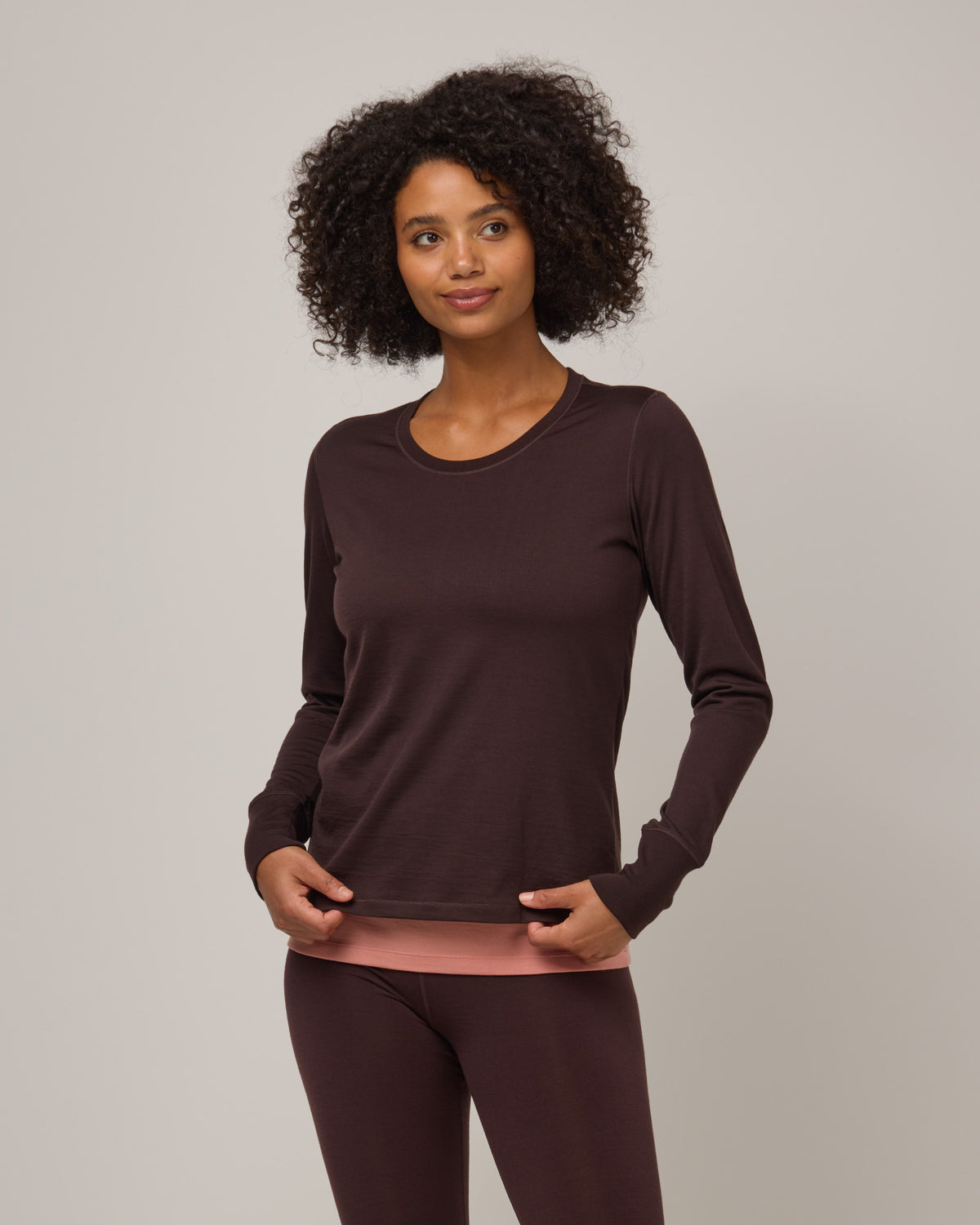 Model wearing Billie Tonal Stitch Tee in Espresso, a dark brown color. Billie Tonal Stitch Tee is a merino wool long sleeve, scoop neck, regular fit tee available in sizes XS-3X.