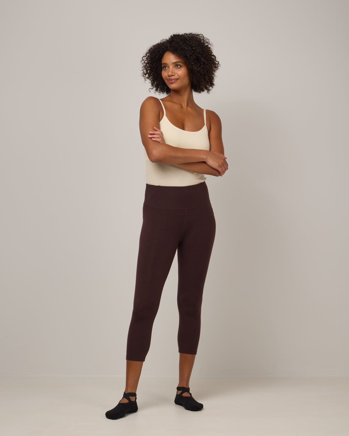 Model wearing Summit Crop Legging in Espresso, a dark brown color. Summit Crop Legging is a merino wool legging available in sizes XS-3X.