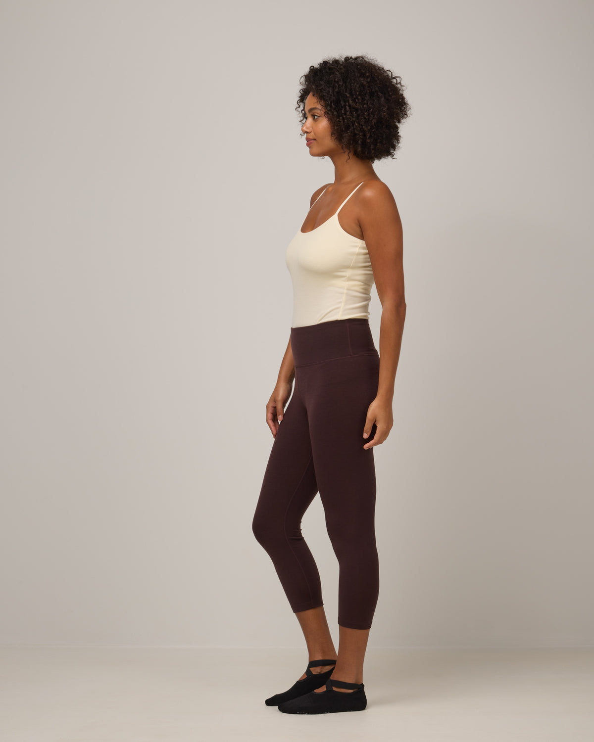 Model wearing Summit Crop Legging in Espresso, a dark brown color. Summit Crop Legging is a merino wool legging available in sizes XS-3X.