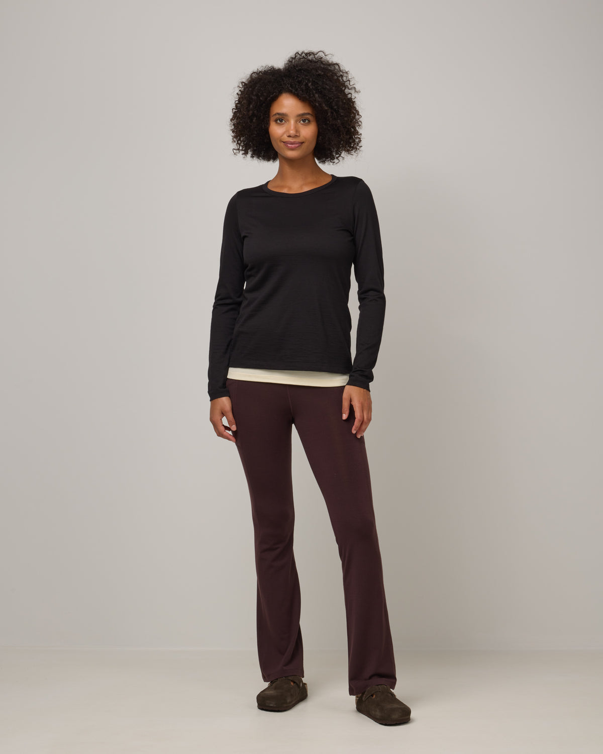 Model wearing Summit Straight Cut Pocket Legging in Espresso, a dark brown color. Summit Straight Cut Pocket Legging is a merino wool legging with pockets available in sizes XS-3X Regular, S-XXL Long.