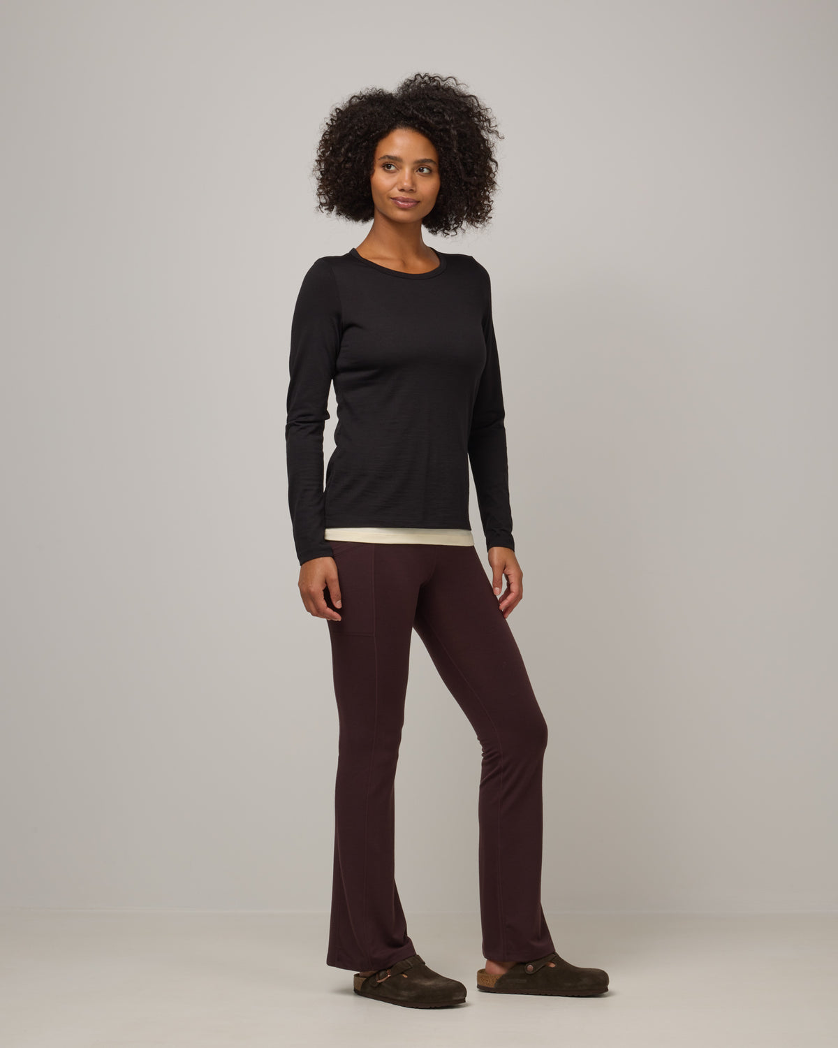 Model wearing Summit Straight Cut Pocket Legging in Espresso, a dark brown color. Summit Straight Cut Pocket Legging is a merino wool legging with pockets available in sizes XS-3X Regular, S-XXL Long.