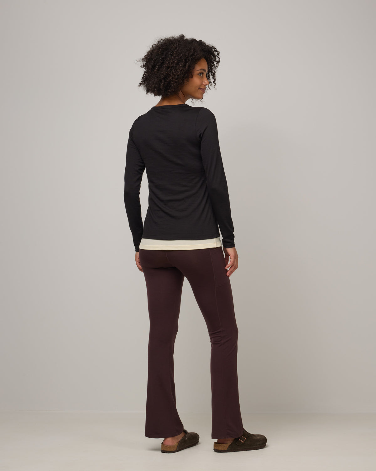 Model wearing Summit Straight Cut Pocket Legging in Espresso, a dark brown color. Summit Straight Cut Pocket Legging is a merino wool legging with pockets available in sizes XS-3X Regular, S-XXL Long.