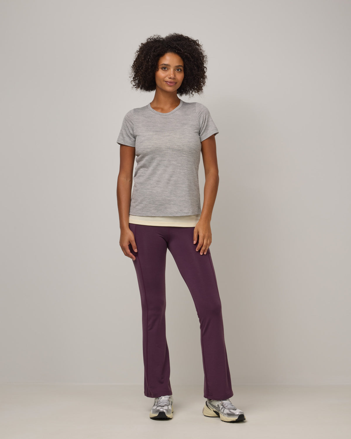 Model wearing Summit Straight Cut Pocket Legging in Dark Marionberry, a deep berry purple color. Summit Straight Cut Pocket Legging is a merino wool legging with pockets available in sizes XS-3X Regular, S-XXL Long.