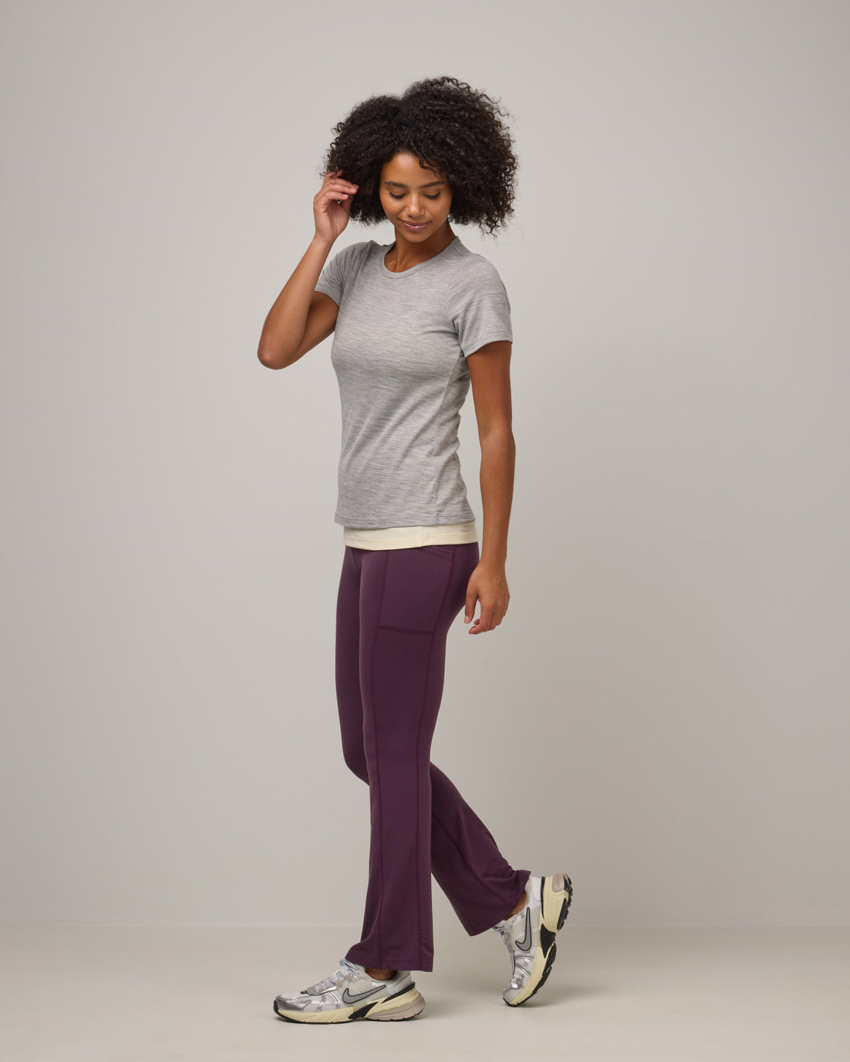 Model wearing Summit Straight Cut Pocket Legging in Dark Marionberry, a deep berry purple color. Summit Straight Cut Pocket Legging is a merino wool legging with pockets available in sizes XS-3X Regular, S-XXL Long.