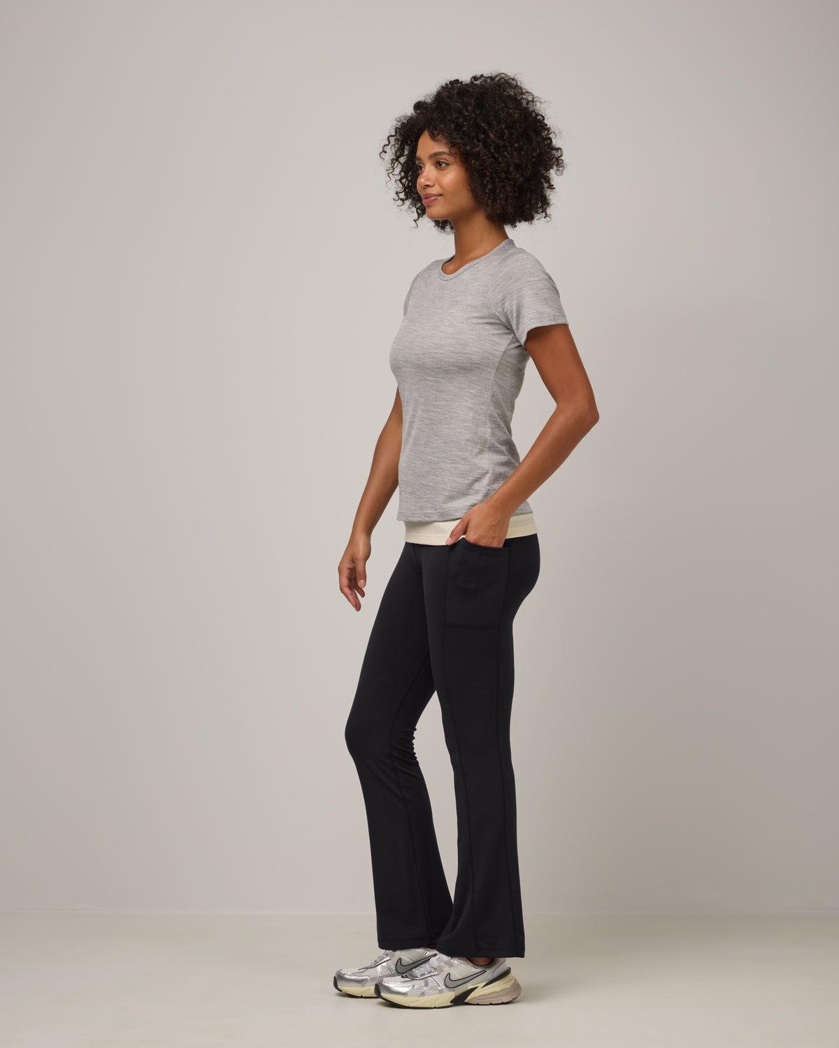 Model wearing Summit Straight Cut Pocket Legging in Black. Summit Straight Cut Pocket Legging is a merino wool legging with pockets available in sizes XS-3X Regular, S-XXL Long.