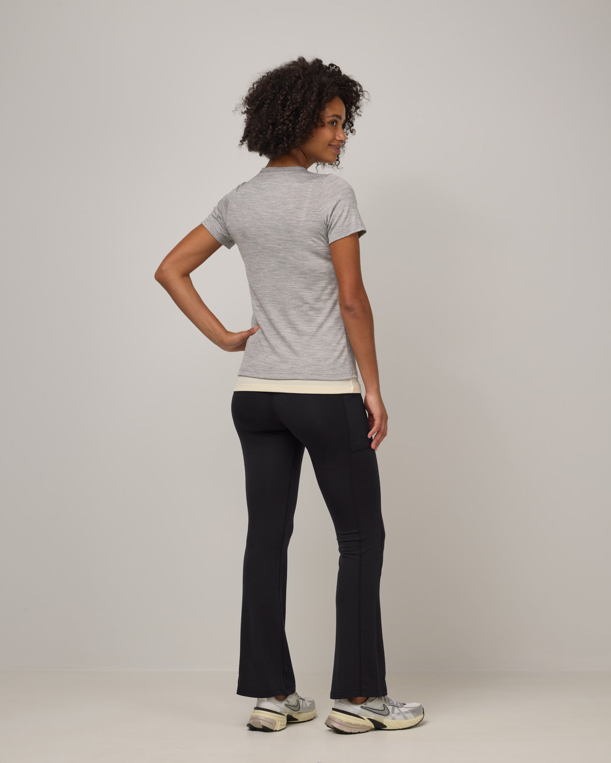 Model wearing Summit Straight Cut Pocket Legging in Black. Summit Straight Cut Pocket Legging is a merino wool legging with pockets available in sizes XS-3X Regular, S-XXL Long.