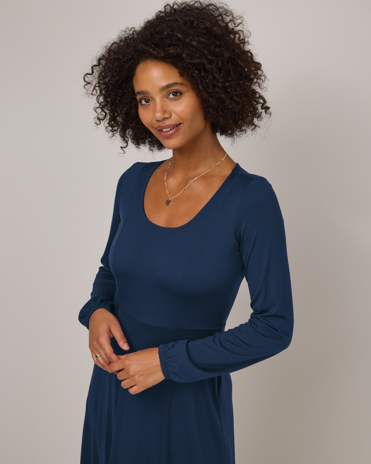 Model wearing Ahna Empire Waist Dress in Marine Blue, a deep royal blue color. Ahna Empire Waist Dress is a merino wool long sleeve, square neck, maxi fit & flare dress with pockets available in sizes XS-3X.