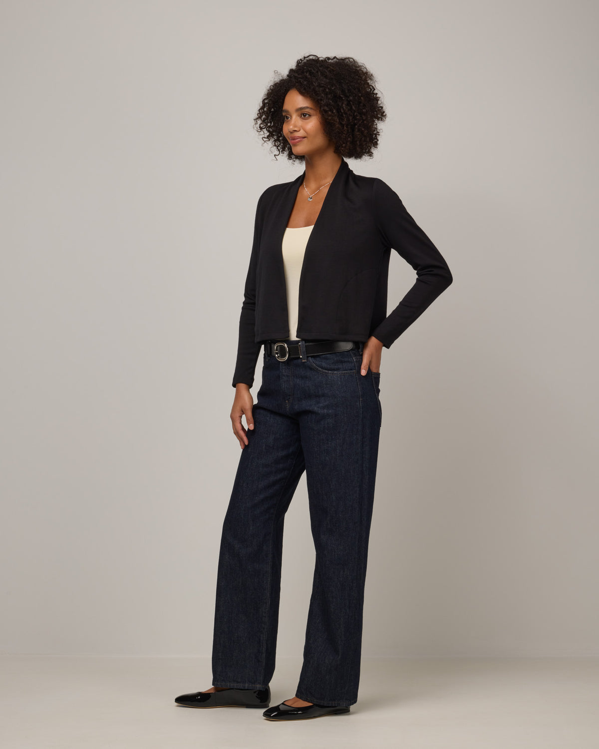 Model wearing Winona Crop Cardigan in Black. Winona Crop Cardigan is a merino wool cardigan with pockets available in sizes XS-XXL.