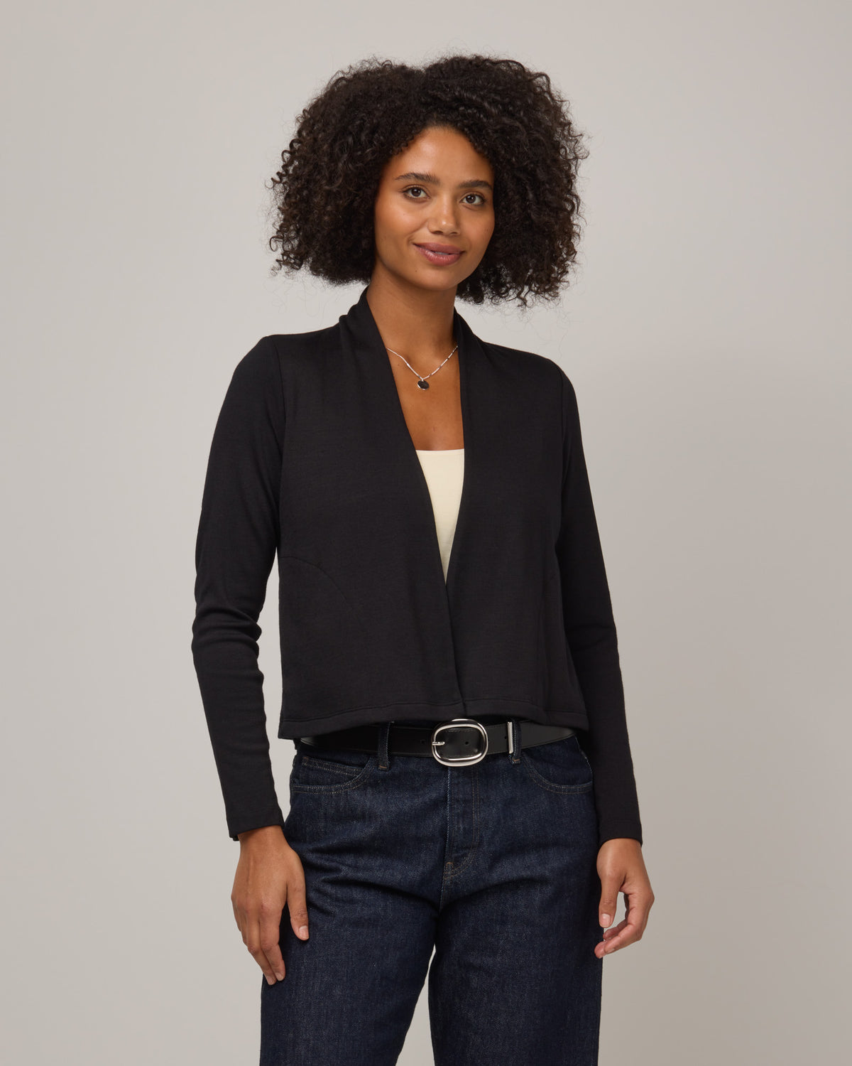 Model wearing Winona Crop Cardigan in Black. Winona Crop Cardigan is a merino wool cardigan with pockets available in sizes XS-XXL.