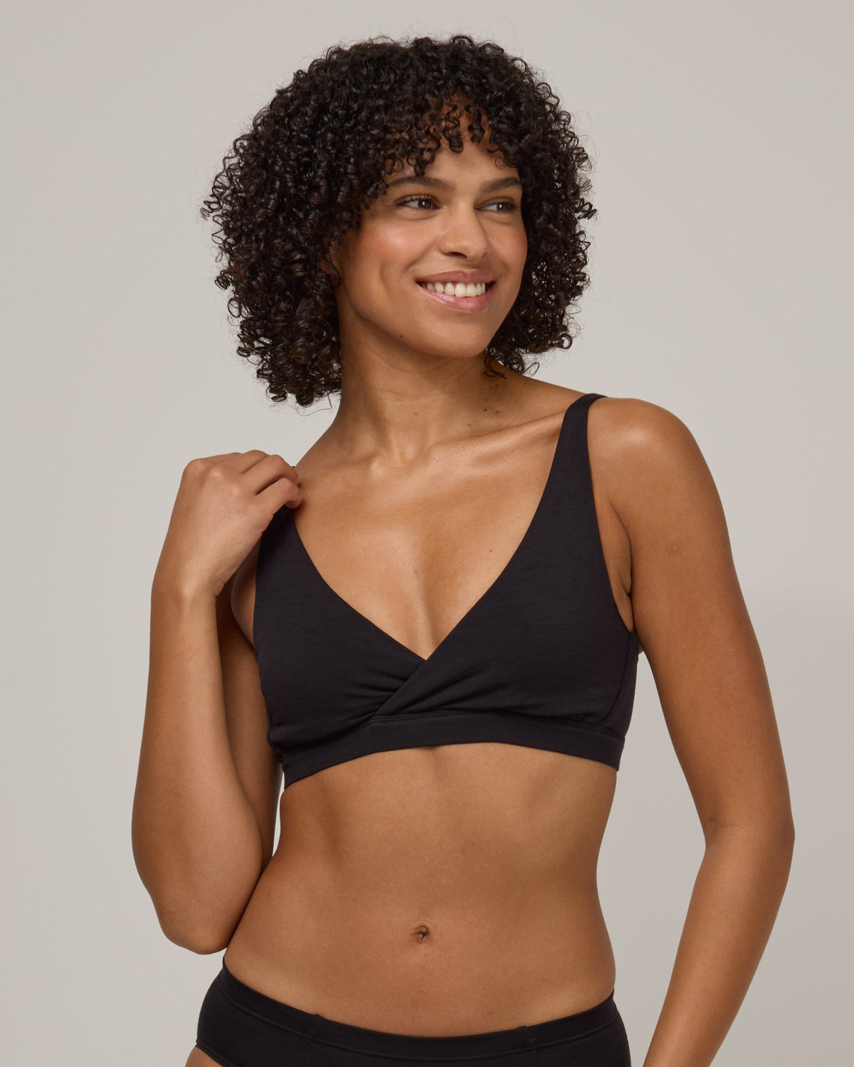 Model wearing Roam Convertible Wrap Bra in Black. Roam Convertible Wrap Bra is a merino wool underwear available in sizes XS-XXL.