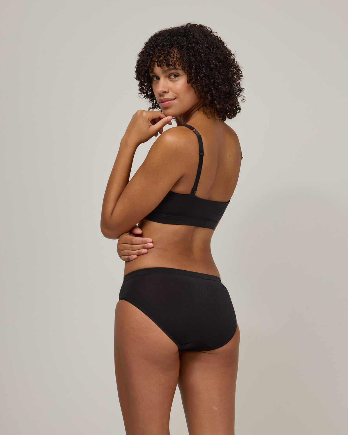 Model wearing Roam Bikini in Black. Roam Bikini is a merino wool underwear available in sizes XS-3X.