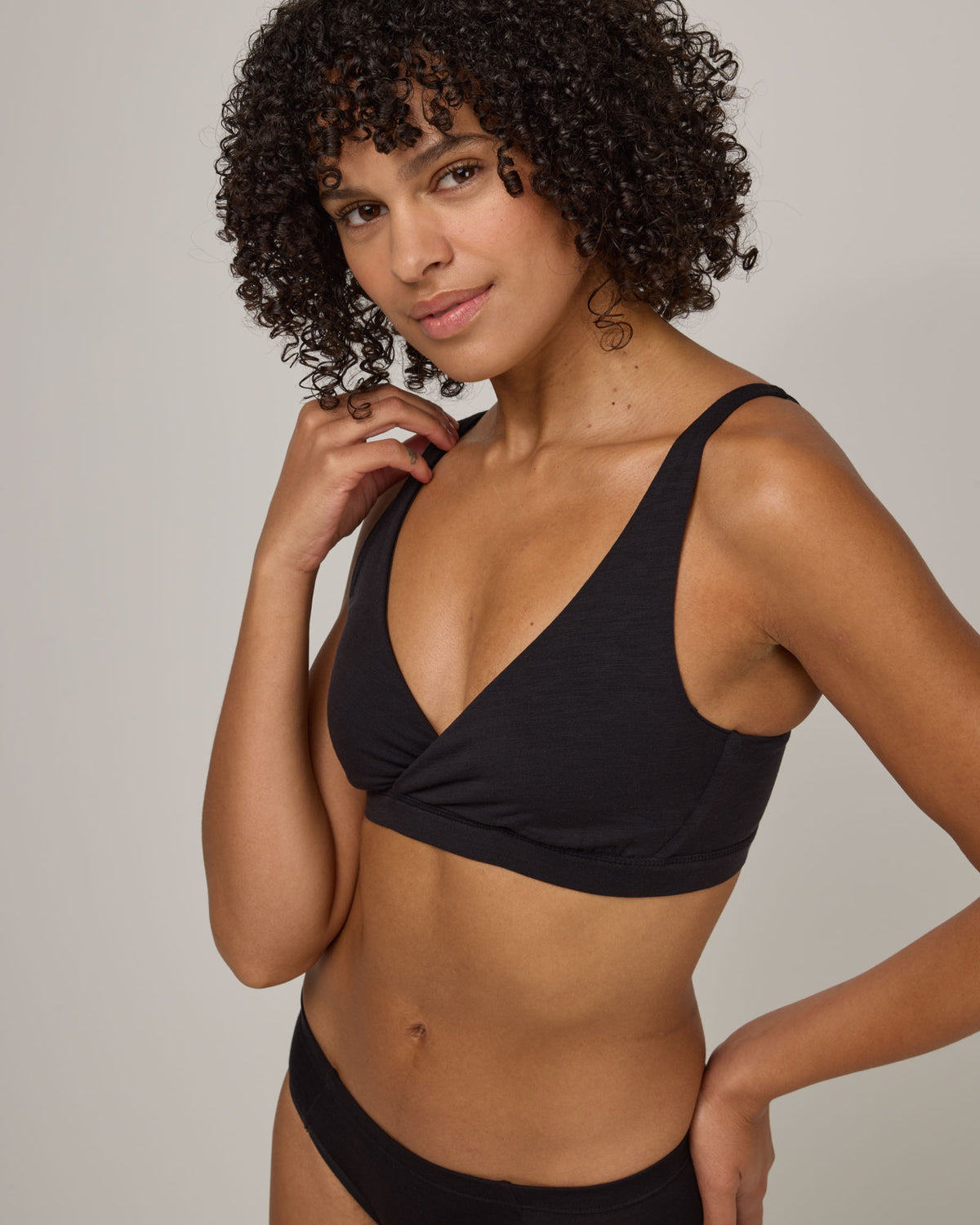 Model wearing Roam Convertible Wrap Bra in Black. Roam Convertible Wrap Bra is a merino wool underwear available in sizes XS-XXL.