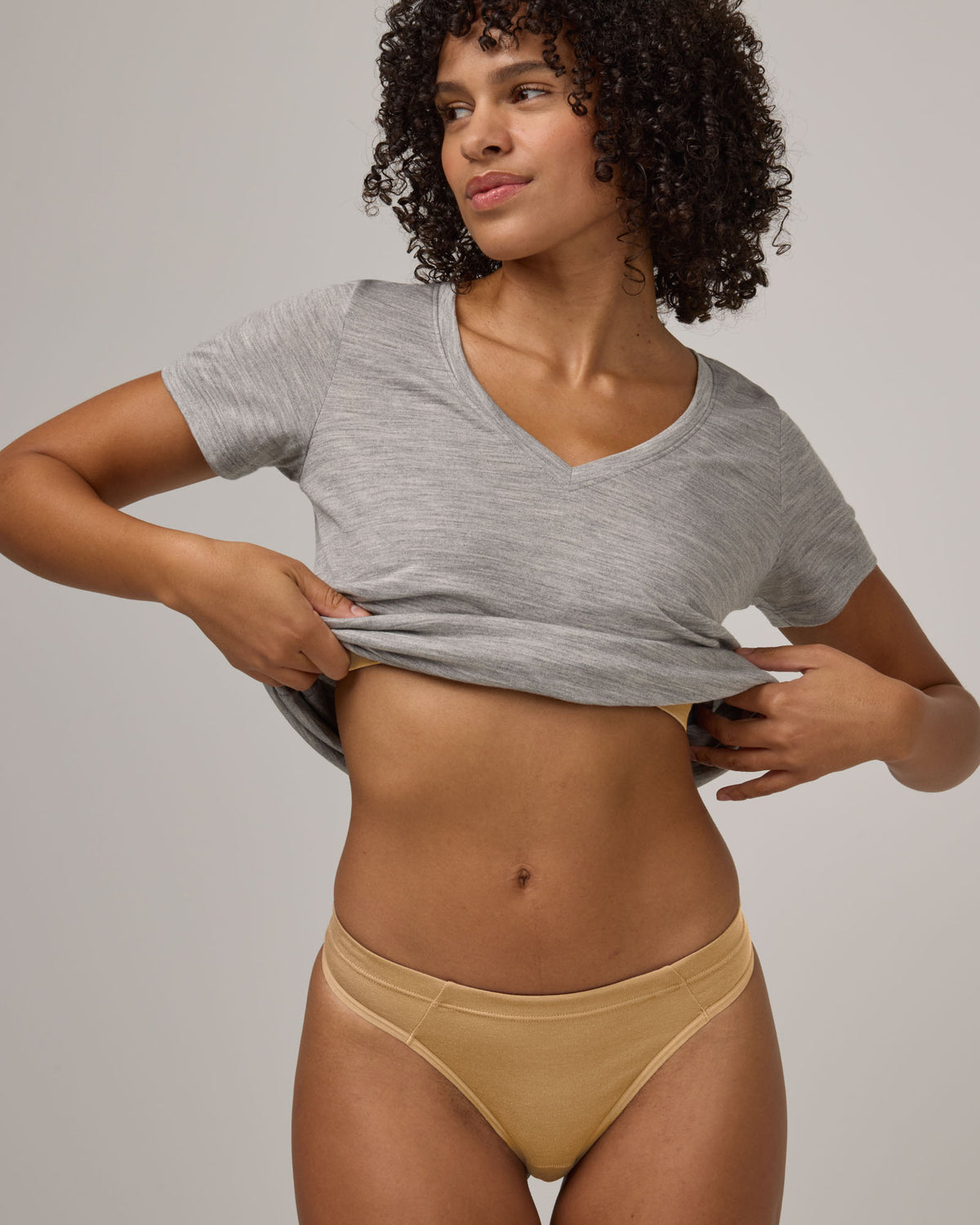 Model wearing Roam Thong in Fawn, a light nude color. Roam Thong is a merino wool underwear available in sizes XS-3X.